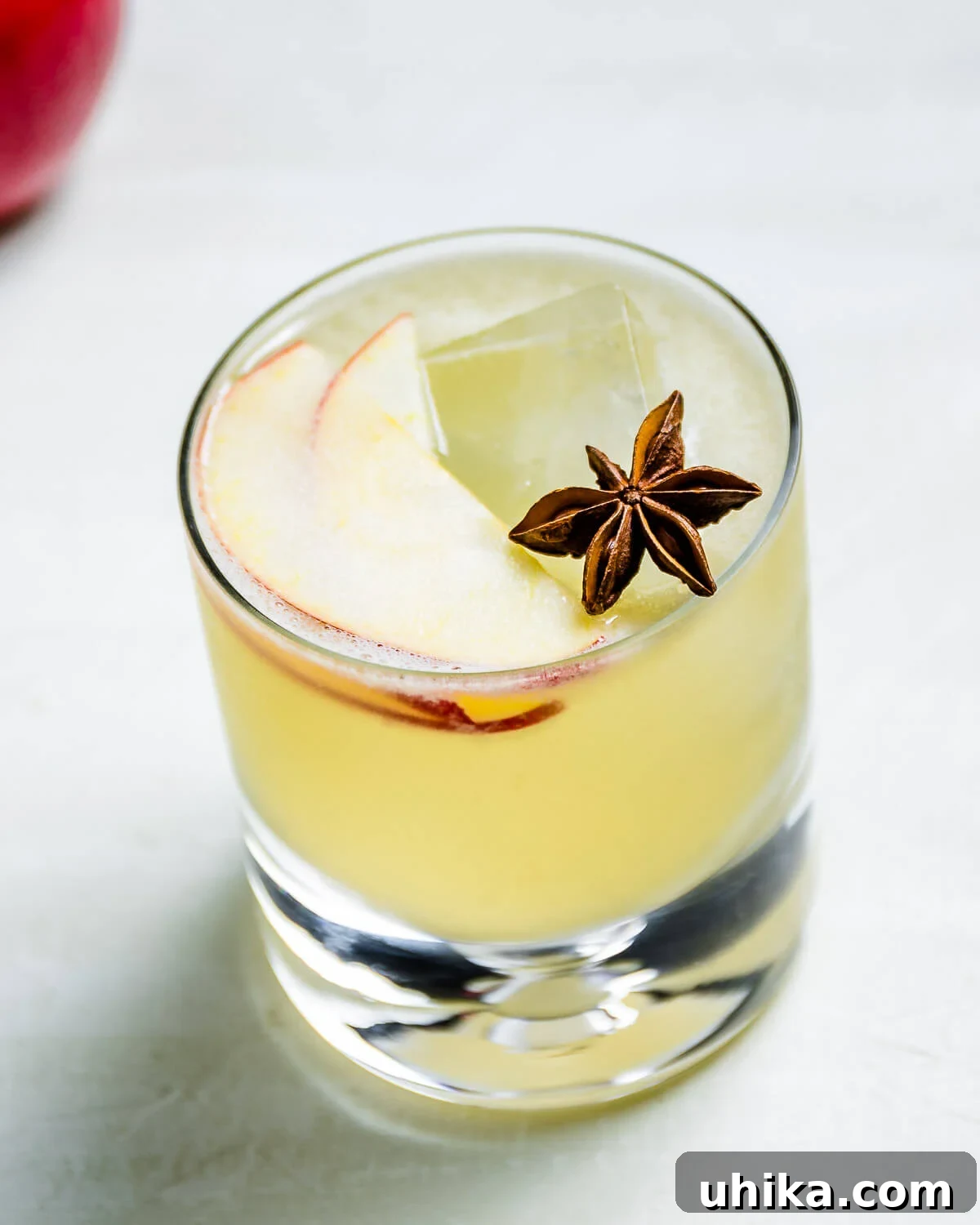 Apple margarita in glass with star anise garnish.