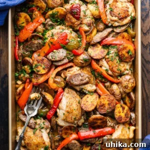 Rustic Italian Chicken and Sausage Skillet 8 Chicken Scarpariello in gold baking pan with serving fork.