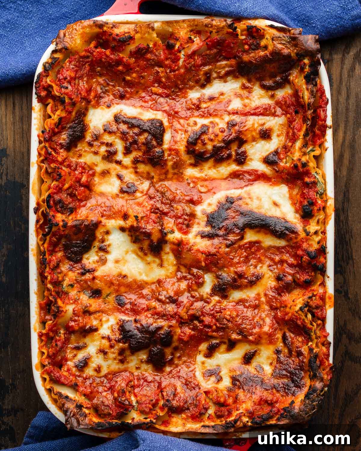 Old-World Comfort: Italian-American Lasagna 2 Lasagna in white baking dish with blue towels around edges.