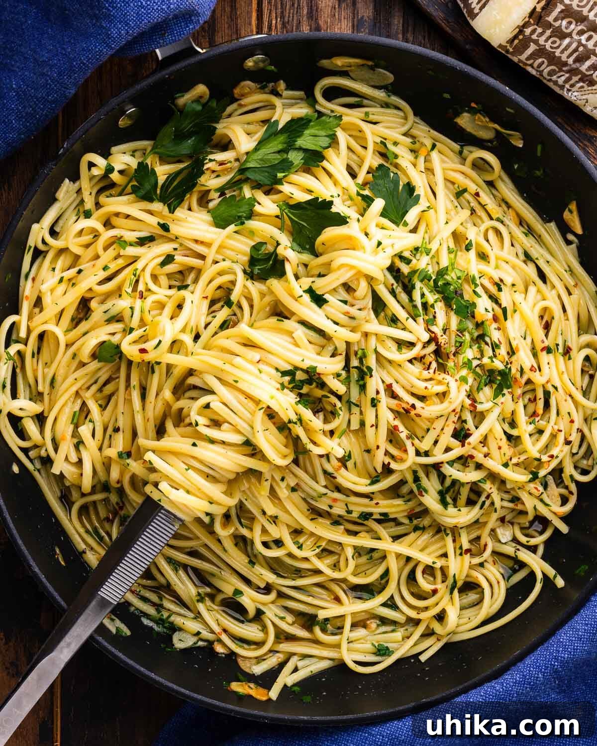Aromatic Garlic and Olive Oil Linguine 7 Linguine Aglio e Olio perfectly tossed in a large black sauté pan, ready to be served, with kitchen tongs nearby.