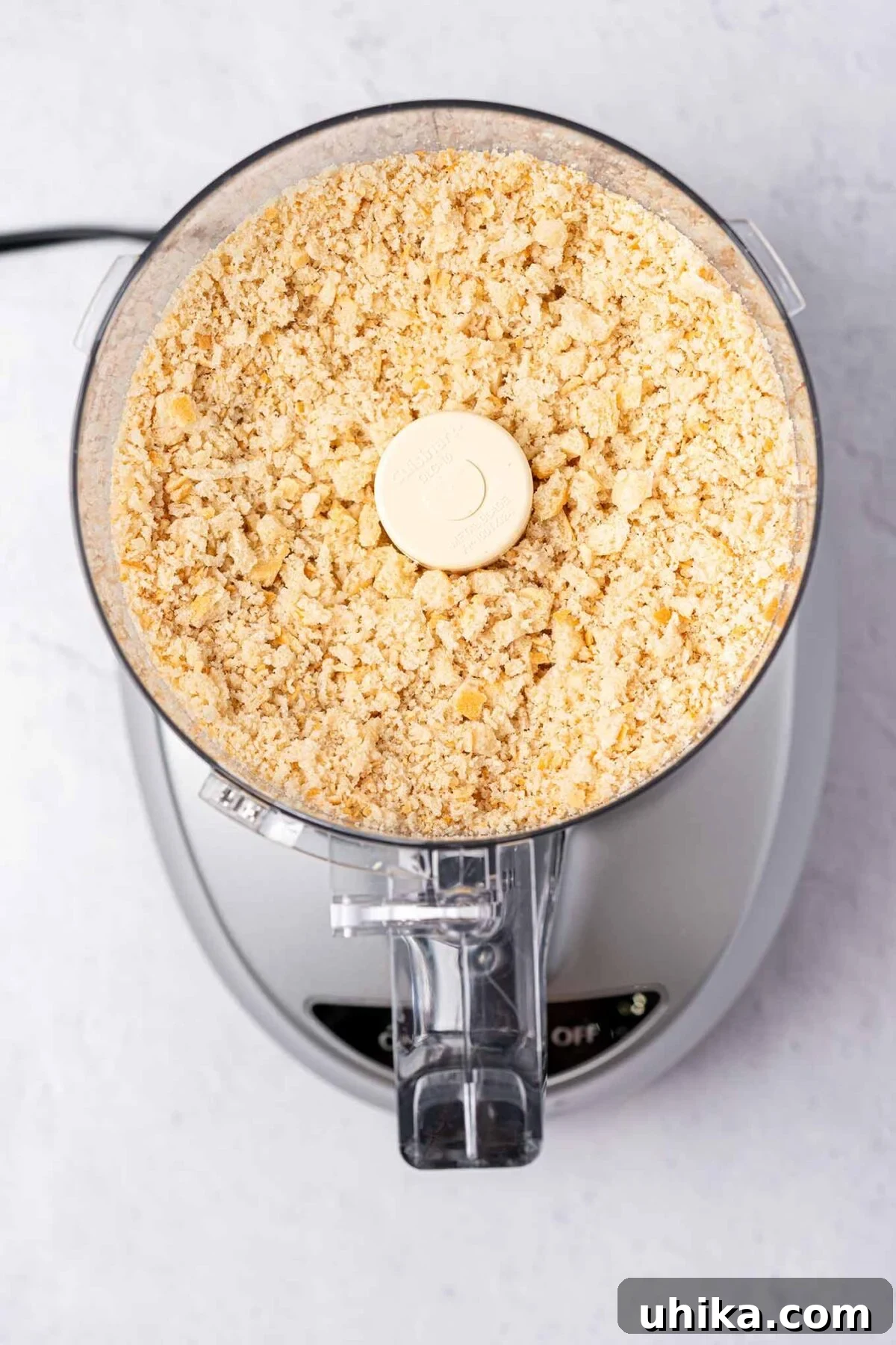 A fresh breadcrumb preparation photo showing an overhead view of breadcrumbs in a food processor to demonstrate size and texture.