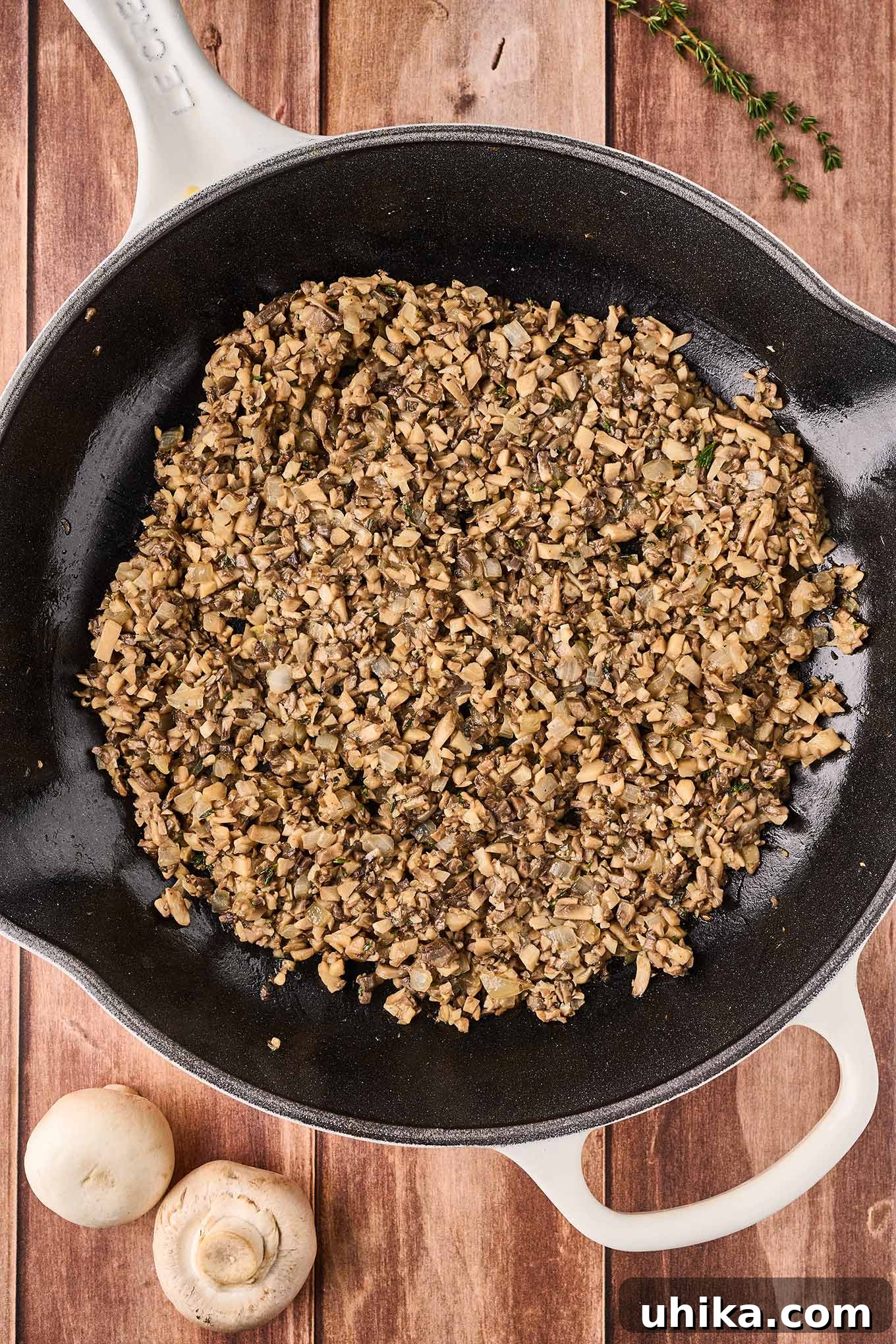 Umami Cloudlets 5 A cast iron pan filled with sautéed chopped mushrooms to squares of puff pastry to make mushroom puff appetizers.