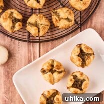 Umami Cloudlets 9 An overhead view of mushroom puff pastry appetizers on a cooling rack next to a small serving plate with four mushroom puffs on it.
