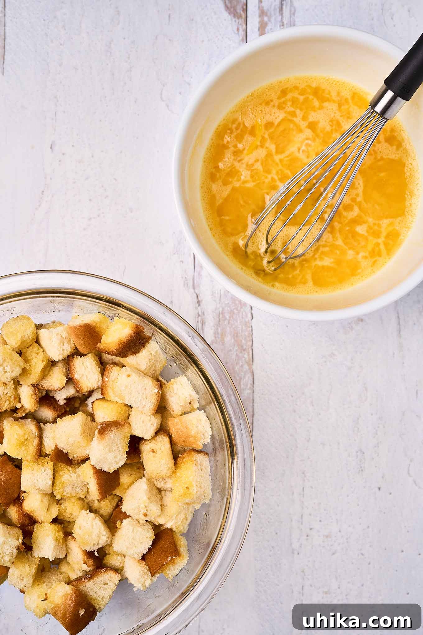 Sunshine Pineapple Bliss 4 A mixing bowl with melted butter, pineapple, and beaten eggs being whisked together, ready to combine with brioche bread cubes for scalloped pineapple.
