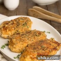 Crispy, golden breaded chicken cutlets topped with a light shallot and thyme glaze, served on a white platter with fresh green beans in the background.