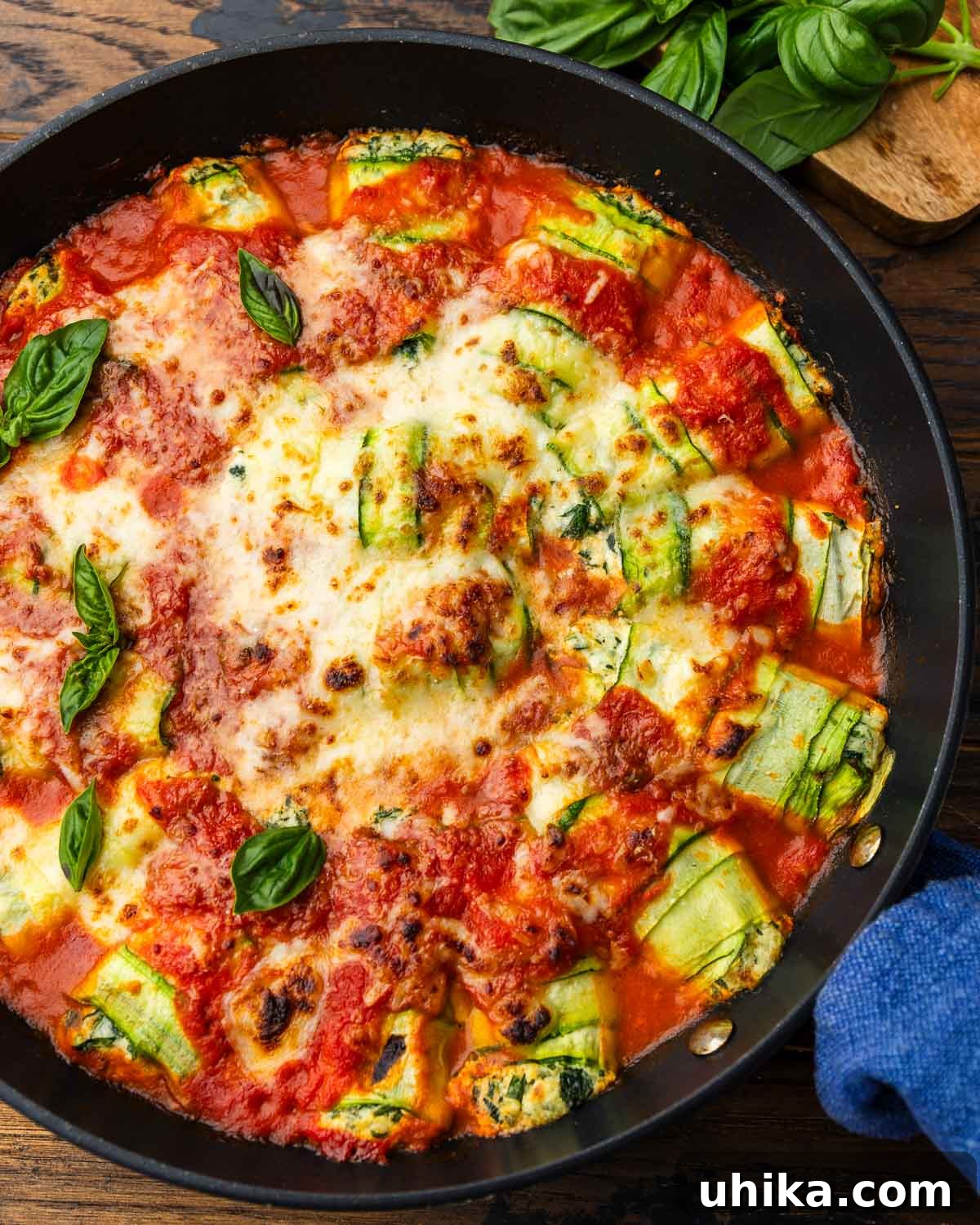 Zucchini Rollatini Summer's Signature Dish 2 Zucchini rollatini in a large black pan, garnished with fresh basil leaves, ready to be served.