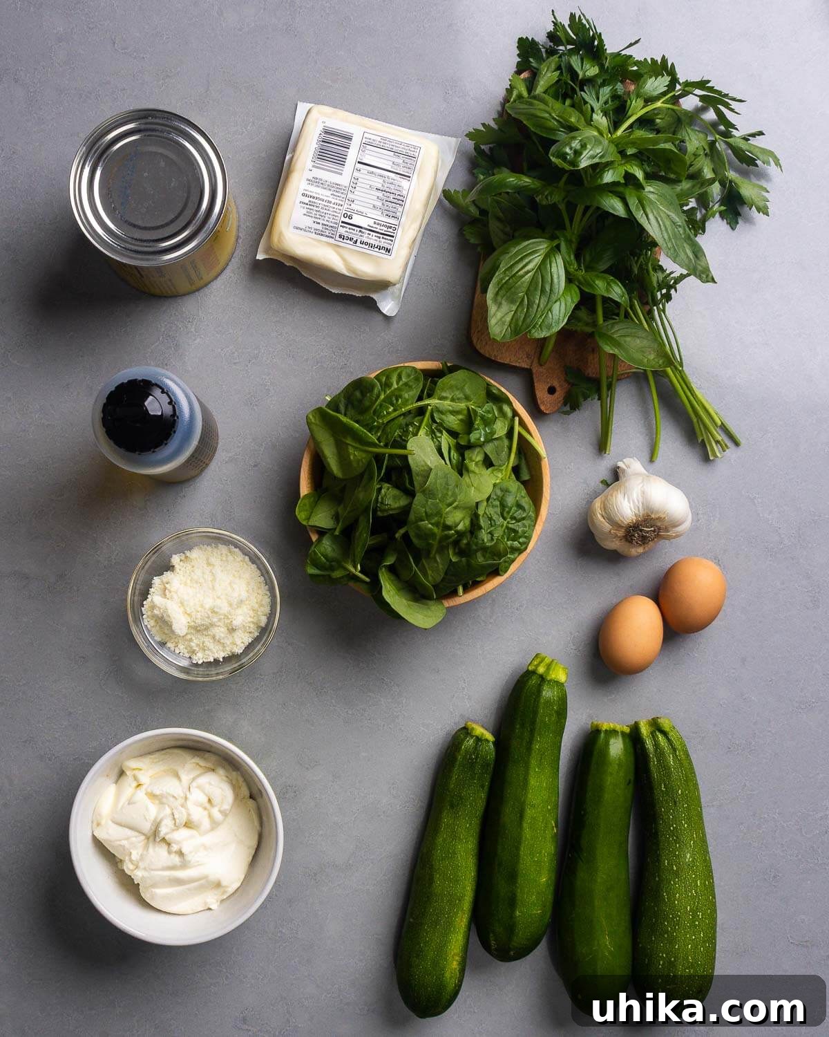 Zucchini Rollatini Summer's Signature Dish 4 A flat lay photograph showcasing all the fresh ingredients for Zucchini Rollatini: tomatoes, mozzarella, basil, parsley, olive oil, spinach, garlic, eggs, pecorino romano, ricotta, and zucchini.