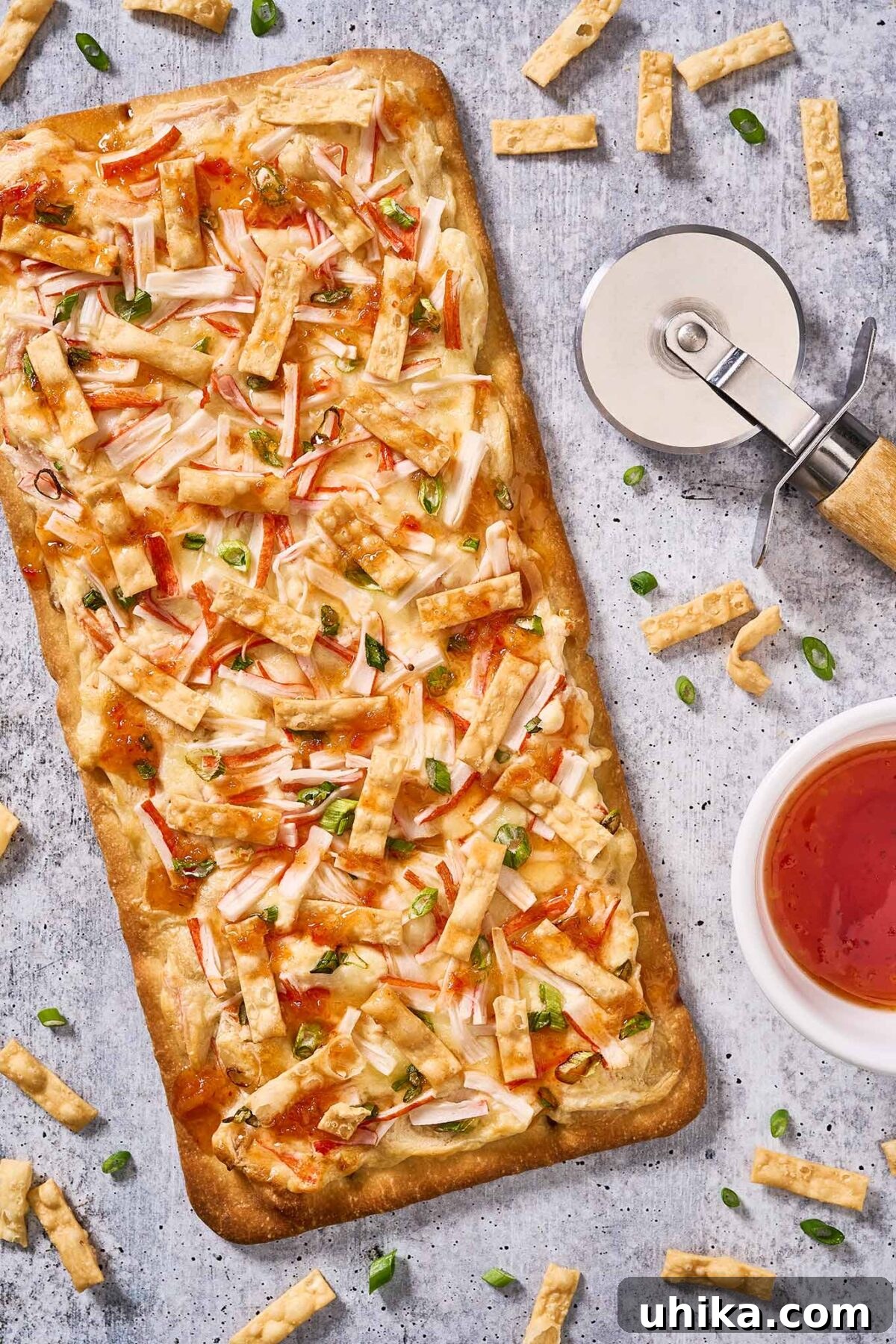 Creamy Crab Rangoon Pizza 6 A whole crab Rangoon flatbread pizza ready to be cut into appetizer-sized serving pieces.