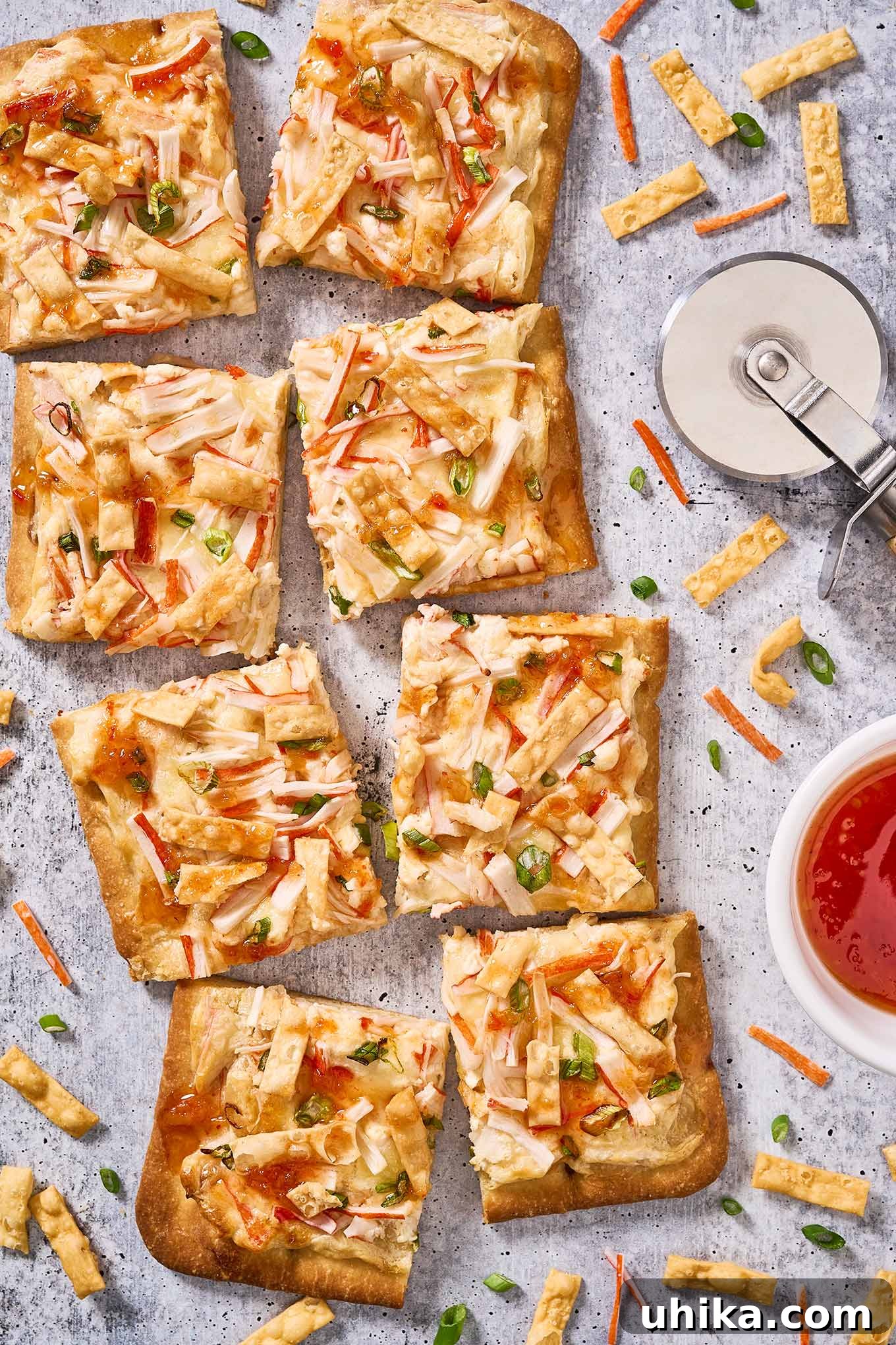 Creamy Crab Rangoon Pizza 7 A whole crab Rangoon flatbread cut into eight squares for serving with the pizza cutter off to the right side.