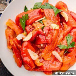 Grey plate of Italian roasted red peppers with parsley and garlic.