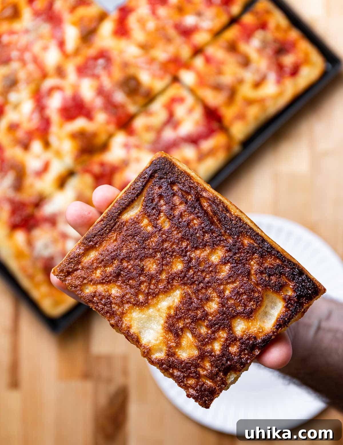 Heirloom Pan Pizza 10 Crisp bottom of Grandma pizza held in hands.