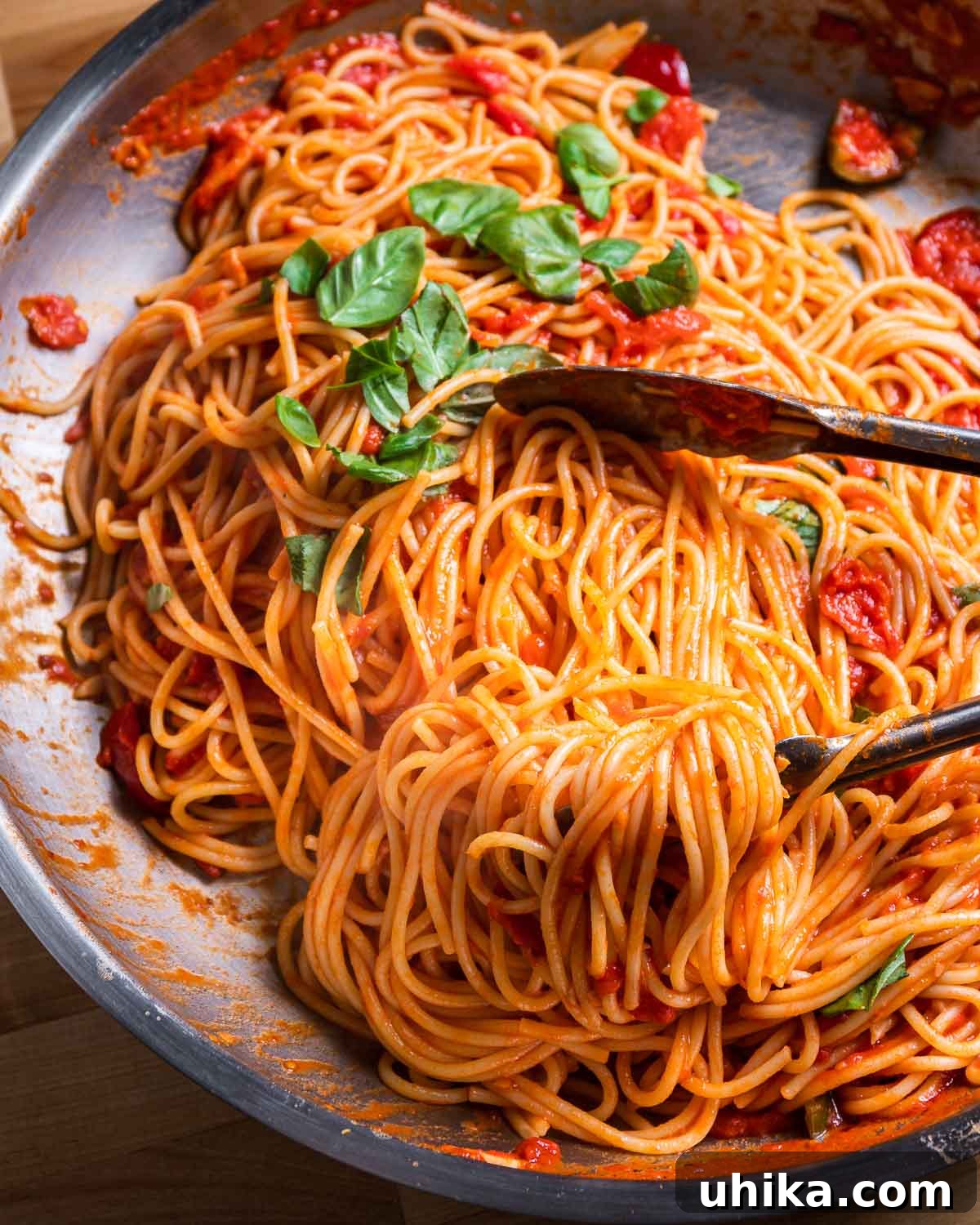 Fiery Tomato Spaghetti 2 Spaghetti arrabbiata in steel pan with tongs.
