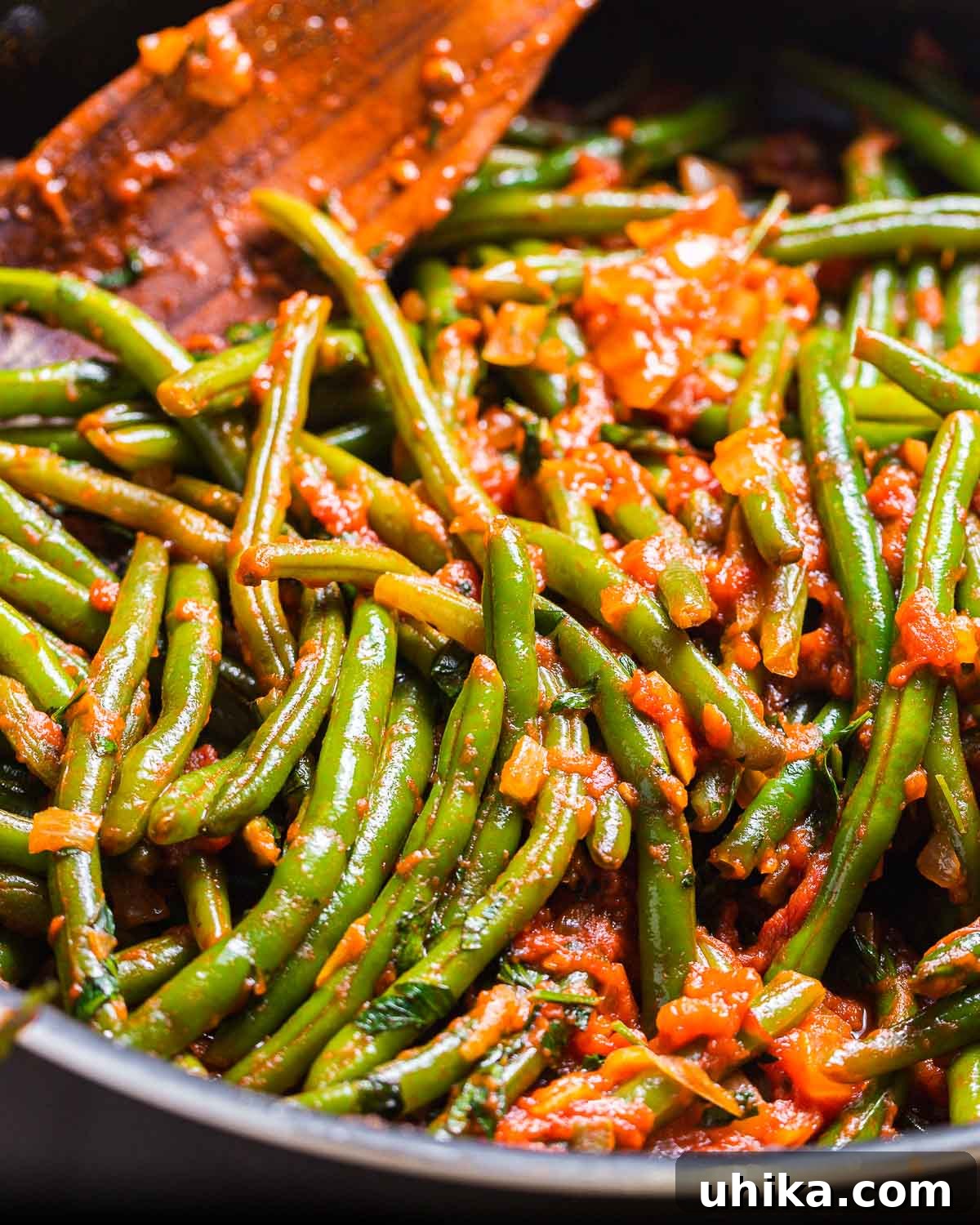 Tender Green Beans Simmered in Rich Tomato Sauce 2 A large pan filled with vibrant green beans stewed in a rich, red tomato sauce, ready to be served as a delightful Italian side dish.