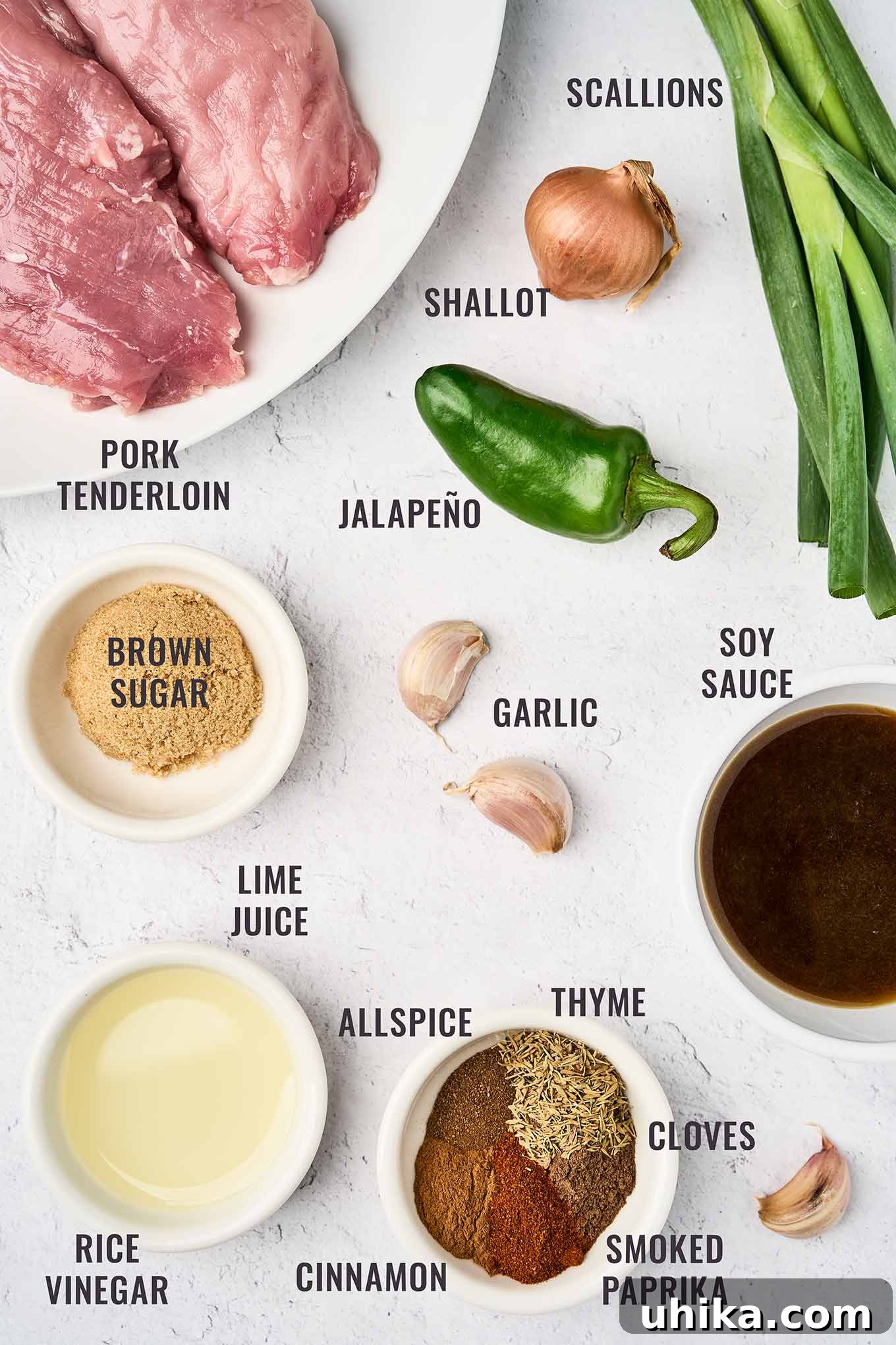 Caribbean Jerk Pork Tenderloin with Bright Garlic-Lime Drizzle 3 A labeled, overhead view of jerk pork tenderloin ingredients; pork, scallions, shallot, jalapeño, garlic, soy sauce, brown sugar, lime juice, rice vinegar, and spices (allspice, thyme, cloves, smoked paprika, and cinnamon).