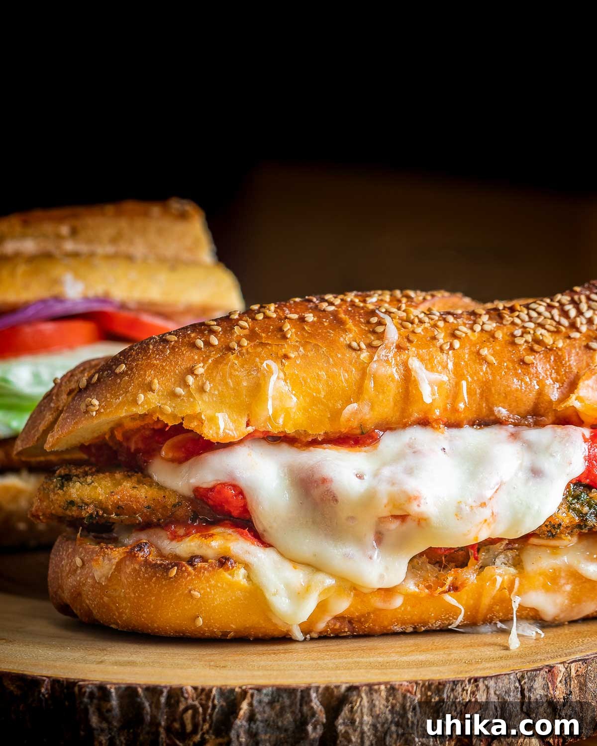 Chicken Parmigiana 11 Delicious Chicken Parmigiana hero sandwich on a wooden board.