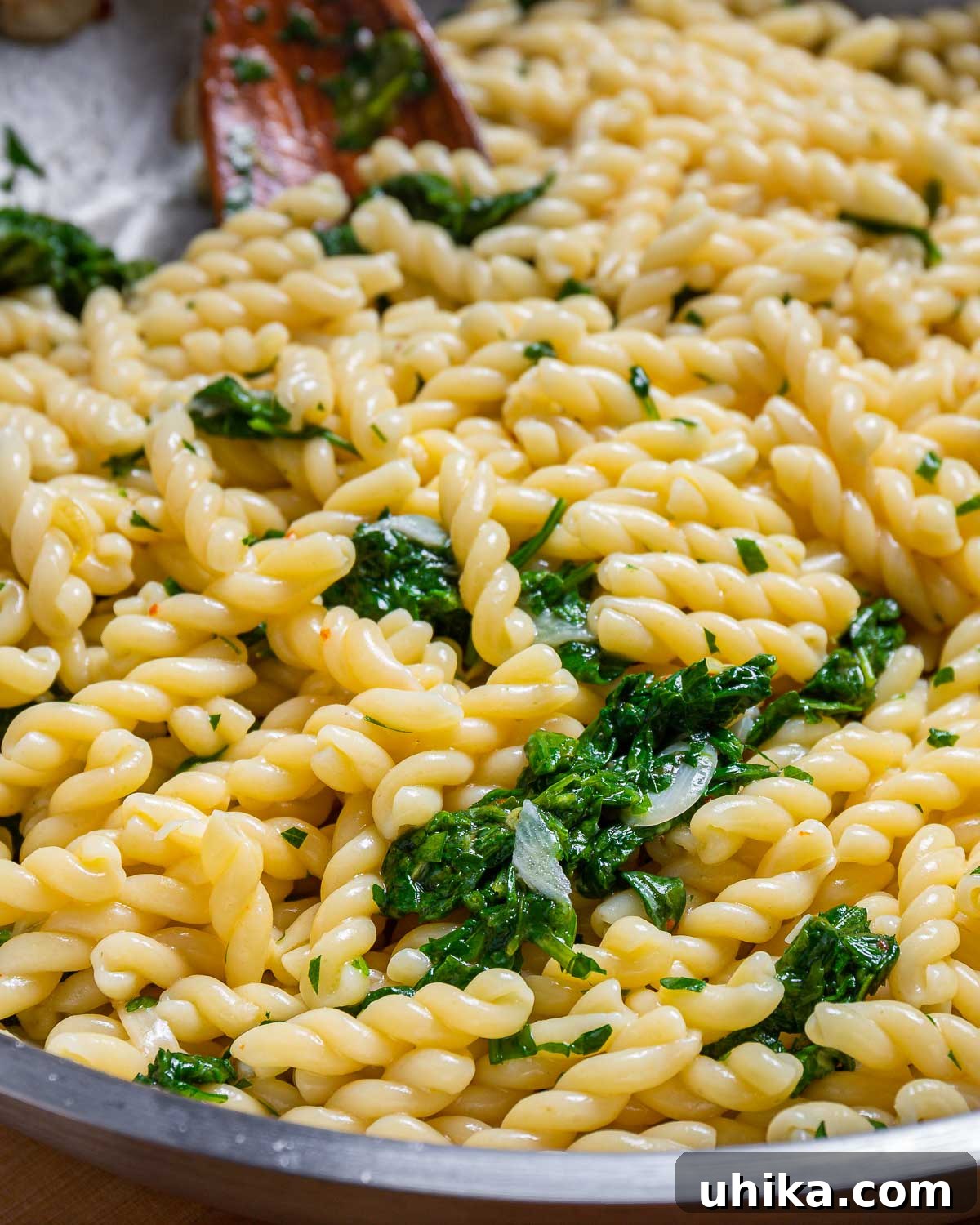 Bright Lemon Arugula Pasta 6 Freshly cooked lemon arugula pasta in a large pan, ready to be served, showcasing the vibrant green arugula and the shiny pasta strands.