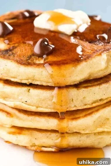 Crafting Memorable Brunch Spreads 6 A stack of four chocolate chip pancakes topped with a few extra chocolate chips, a pat of butter, and a drizzle of maple syrup.