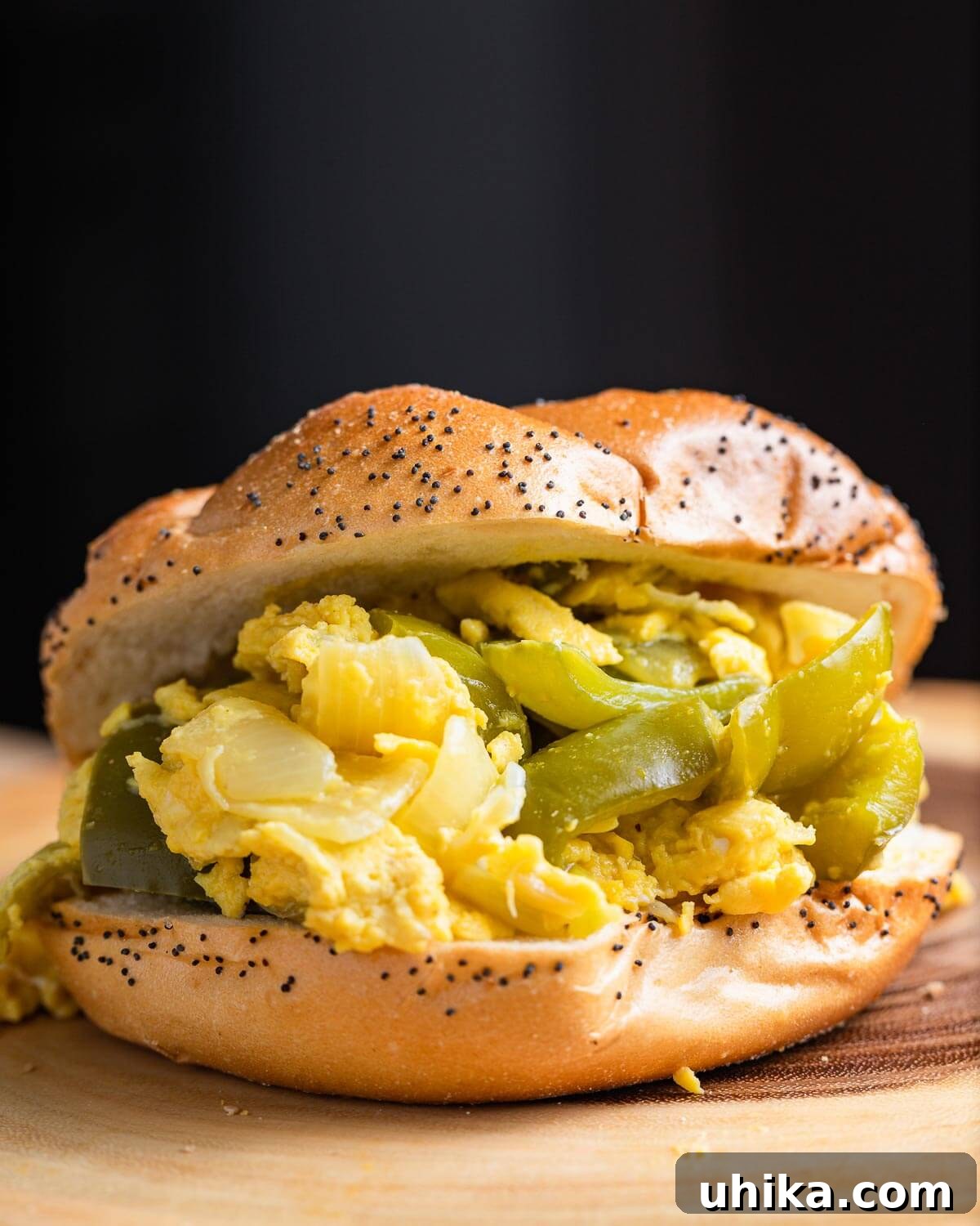 Savory Pepper & Egg Stack 2 Pepper and egg sandwich on wood board, showcasing its hearty ingredients and golden-brown eggs.