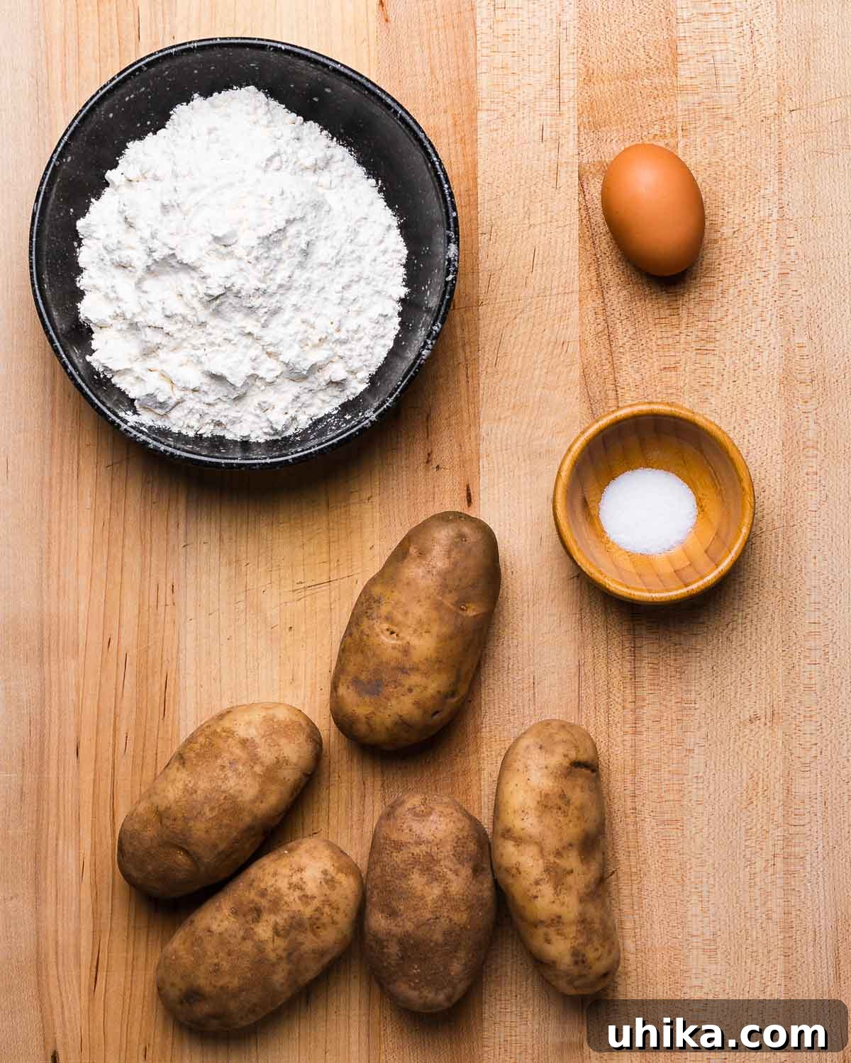 Perfect Potato Pillows 3 Ingredients shown: bowl of flour, egg, salt, and russet potatoes.