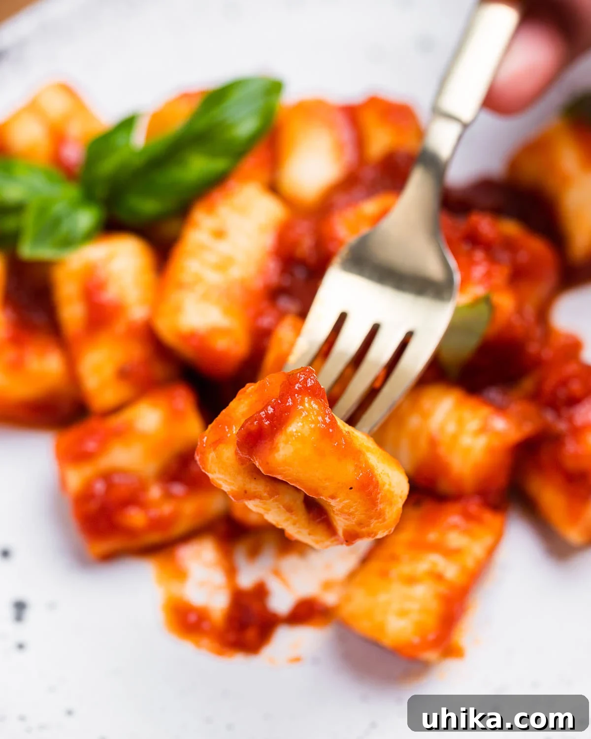 Perfect Potato Pillows 9 Fork holding one piece of potato gnocchi in tomato sauce.