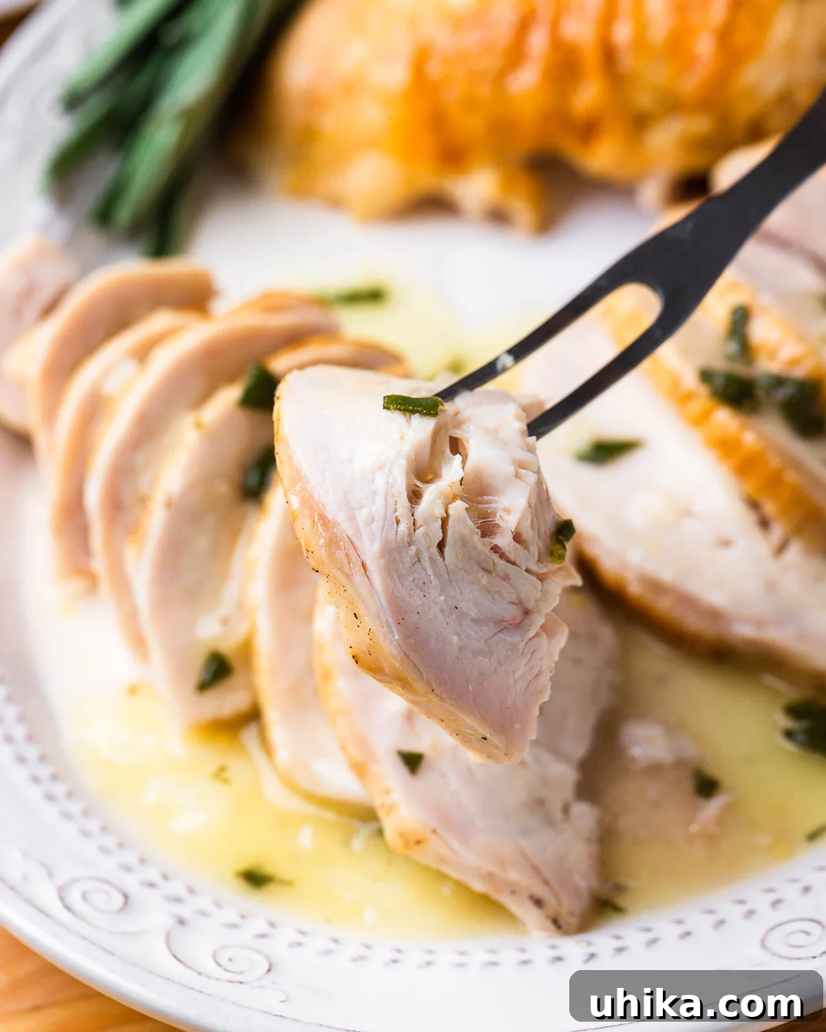 Succulent Dry Brined Turkey Breast 3 Carving fork holding one piece of turkey.