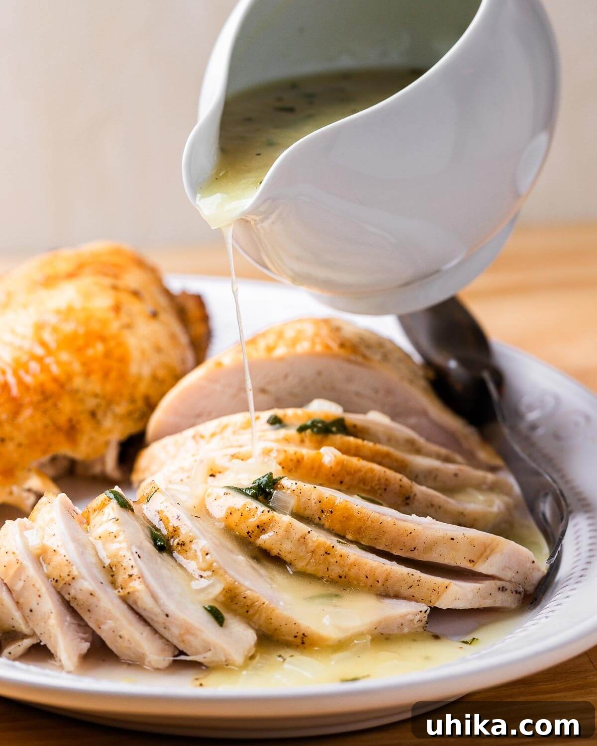 Succulent Dry Brined Turkey Breast 9 Gravy being poured on platter of carved turkey breast.