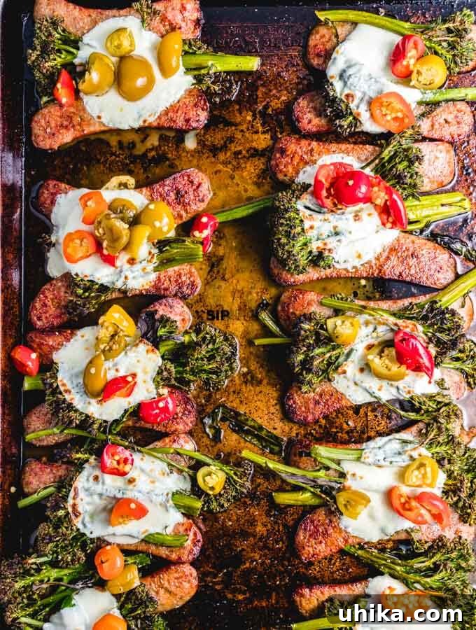 One-Pan Roasted Sausage & Broccolini 7 The stunning final presentation of the roasted broccolini sheet pan dinner, garnished with Italian sausage, melted fresh mozzarella, and vibrant cherry peppers, ready to be served.