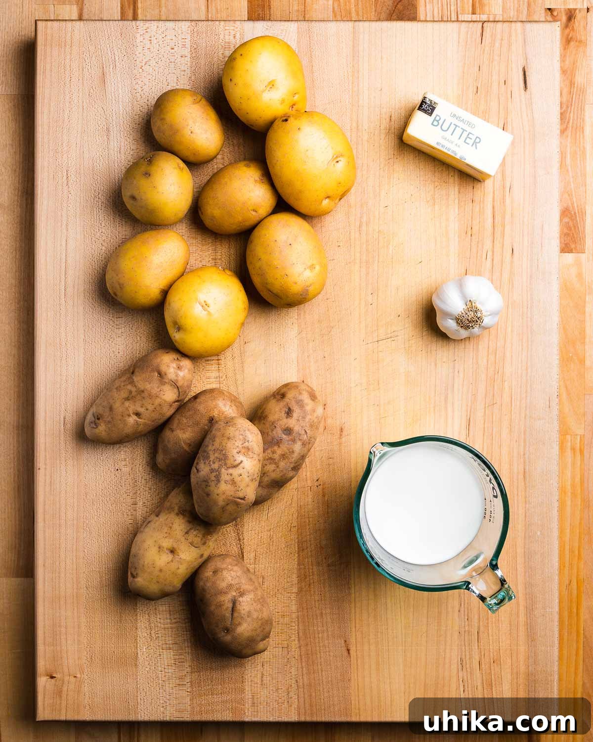 Creamy Roasted Garlic Mashed Potatoes 3 Key ingredients for roasted garlic mashed potatoes including Yukon Gold and Russet potatoes, butter, whole milk, and fresh garlic cloves.