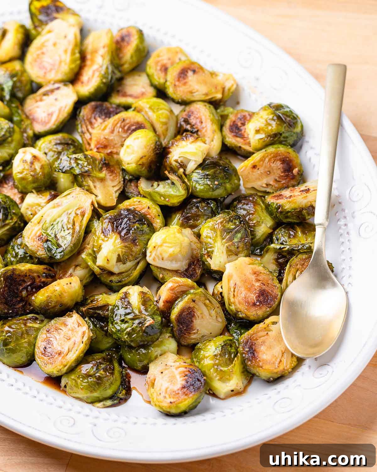 Glazed Honey Balsamic Brussels Sprouts 2 A serving of perfectly roasted honey balsamic Brussels sprouts in a white bowl, garnished with fresh herbs, ready to be enjoyed.