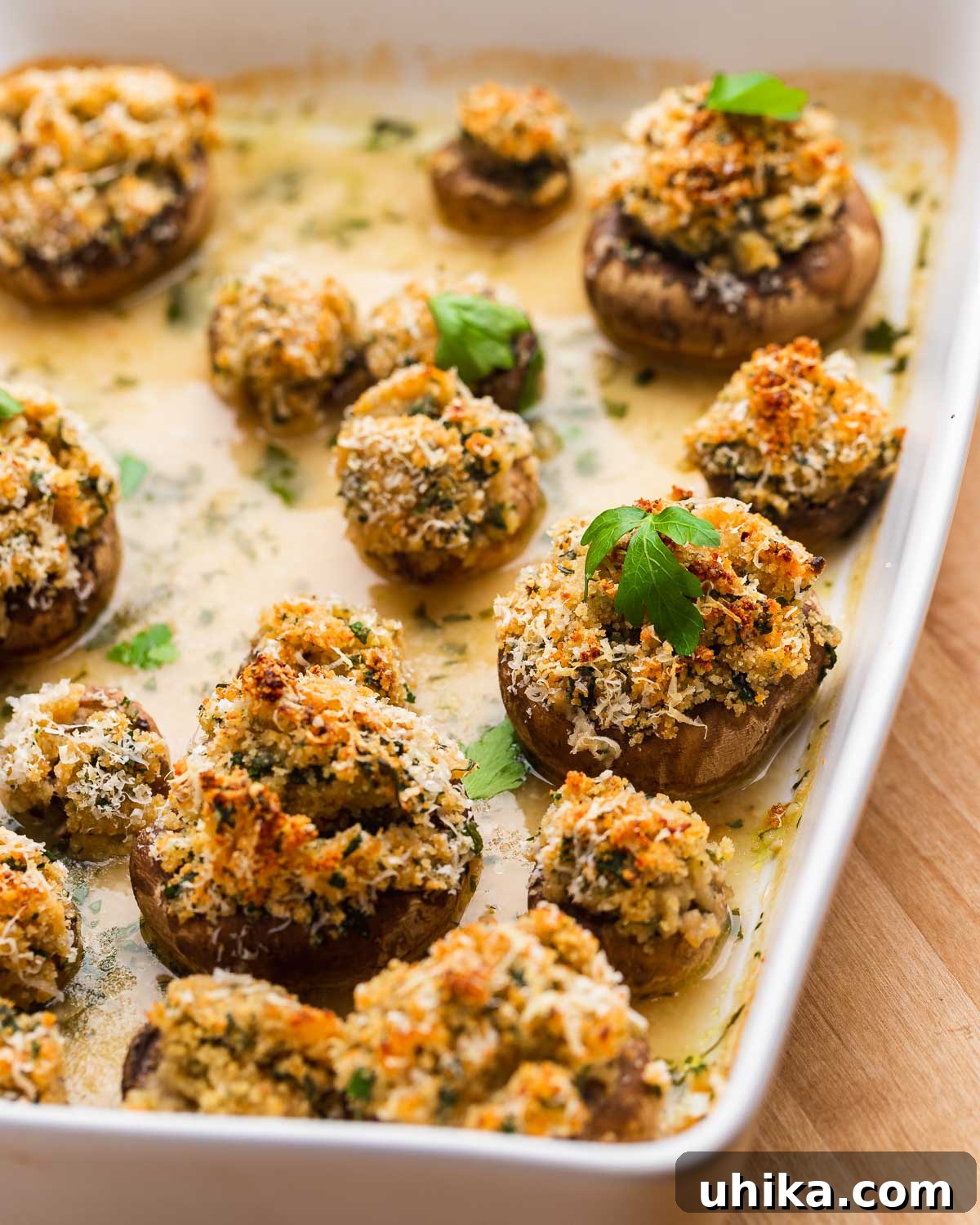 Parmesan & Herb Stuffed Mushrooms 8 White baking dish with cooked stuffed mushrooms.