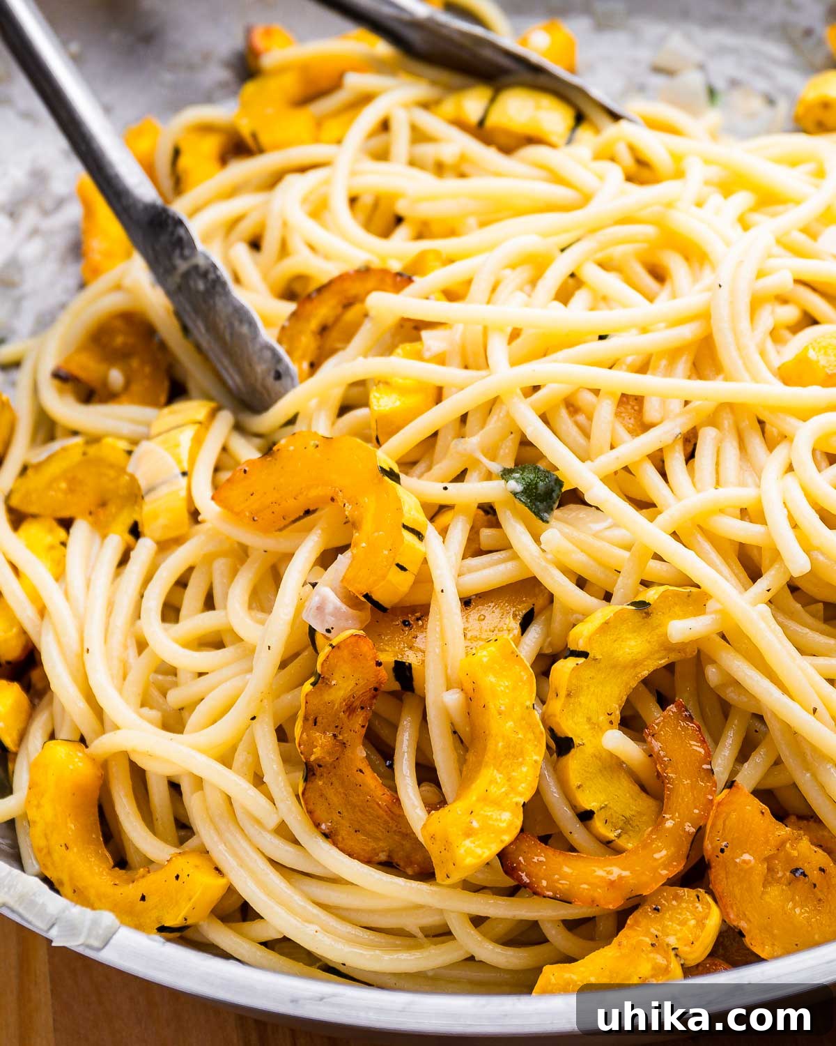 Large pan with bucatini pasta and roasted delicata squash.