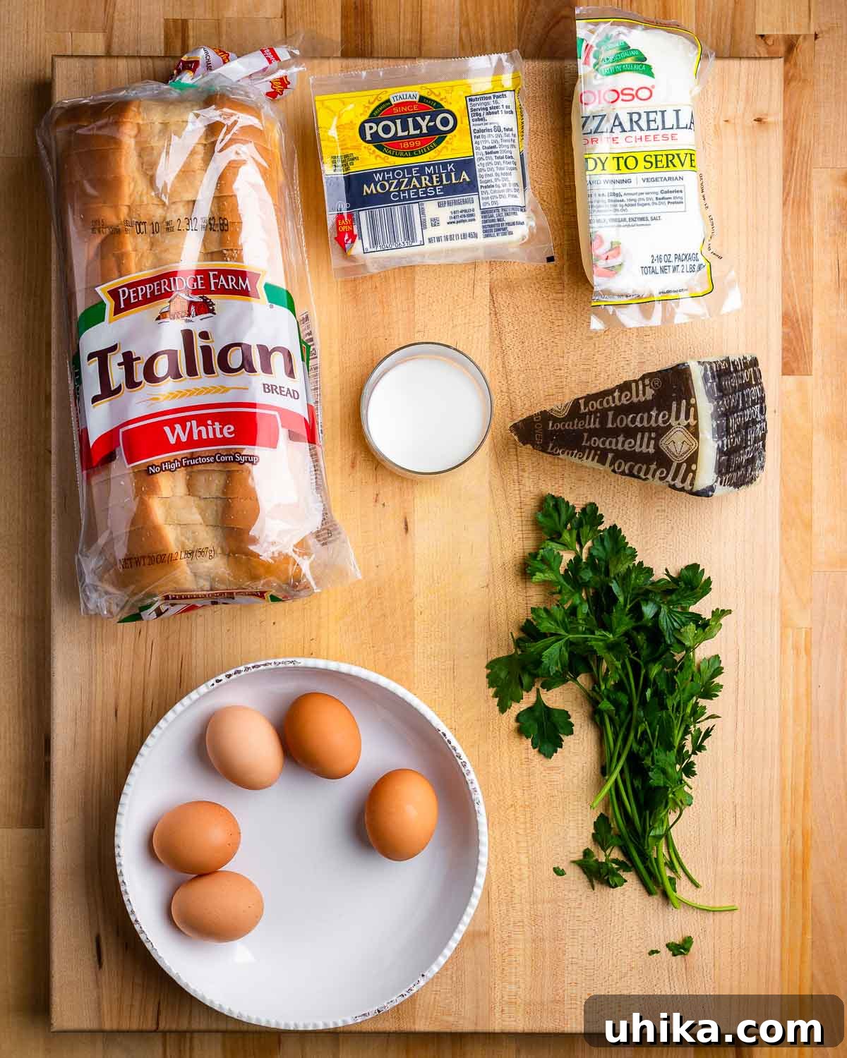 Golden Fried Mozzarella Toast 3 A flat lay showing all the essential ingredients for Mozzarella en Carrozza: Italian style white bread, block mozzarella, Pecorino Romano cheese, fresh milk, eggs, and minced parsley.