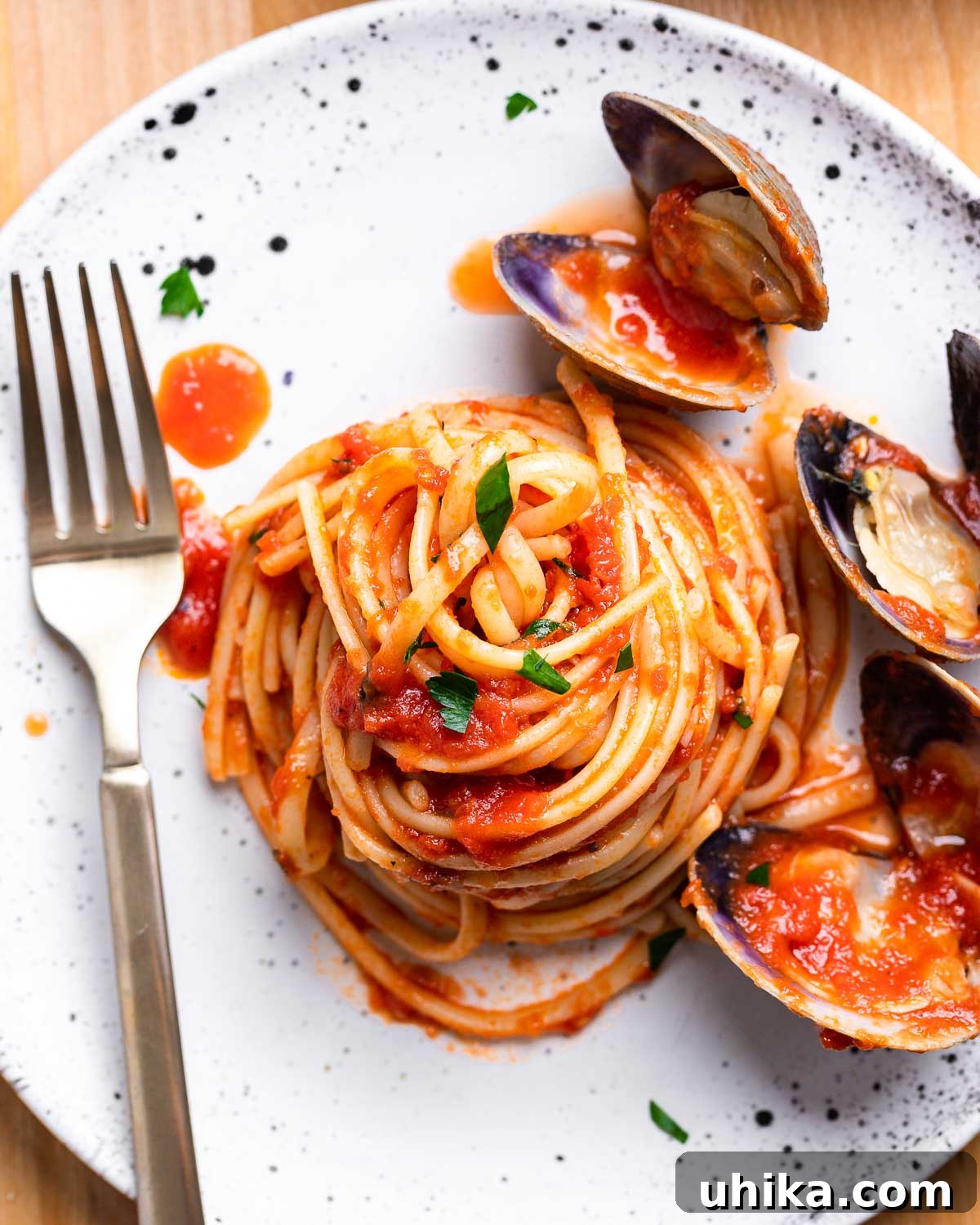 Clam Linguine Delight 2 A small white plate showcasing a generous serving of linguine adorned with succulent red clam sauce.