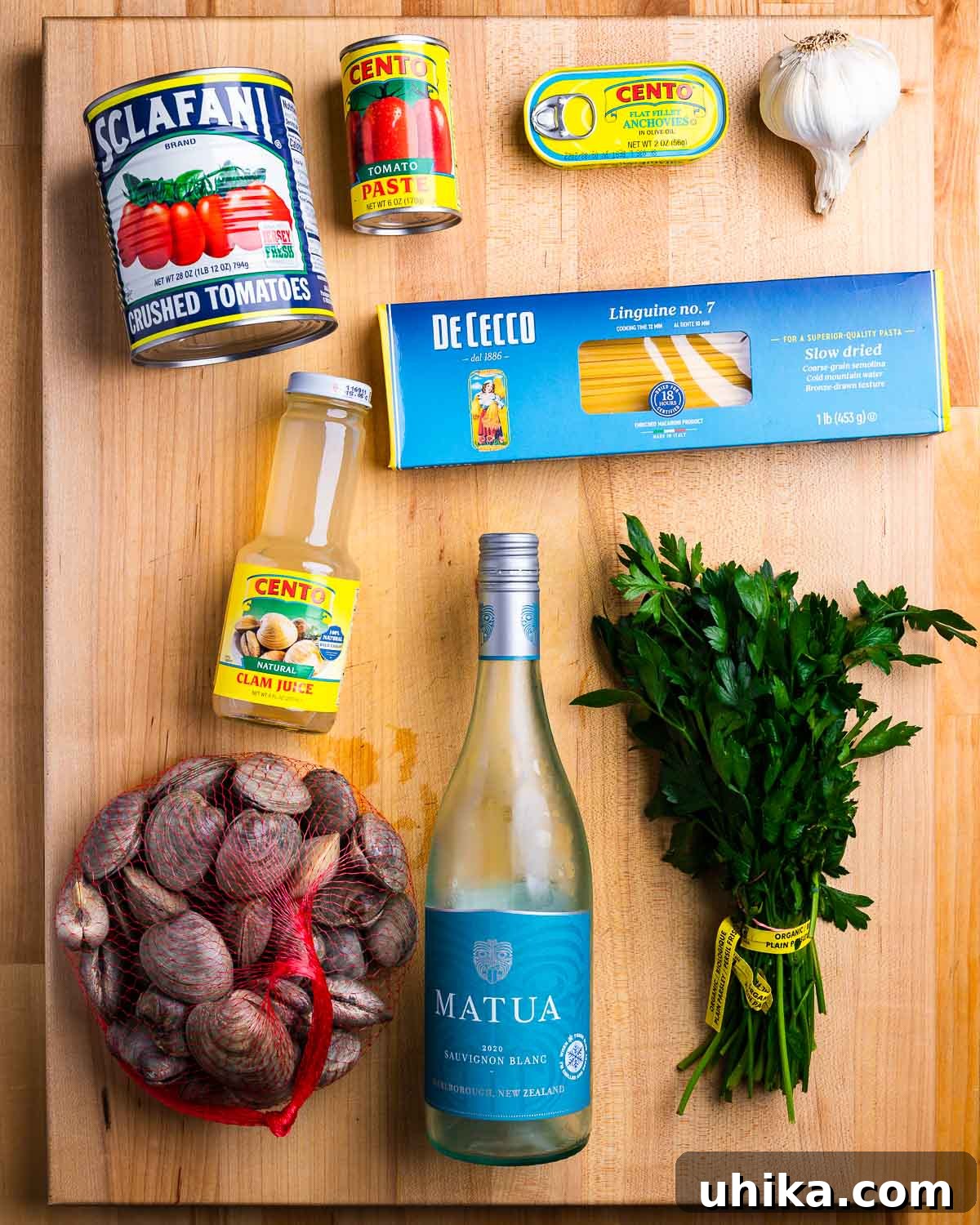 Clam Linguine Delight 3 A vibrant display of ingredients for linguine with red clam sauce, including plum tomatoes, tomato paste, anchovies, garlic, linguine, clam juice, fresh clams, white wine, and parsley, ready for preparation.