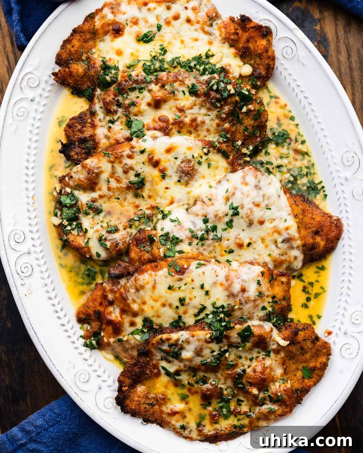 Ultimate Garlic Chicken Scampi 2 Chicken scampi in white platter, garnished with fresh parsley.