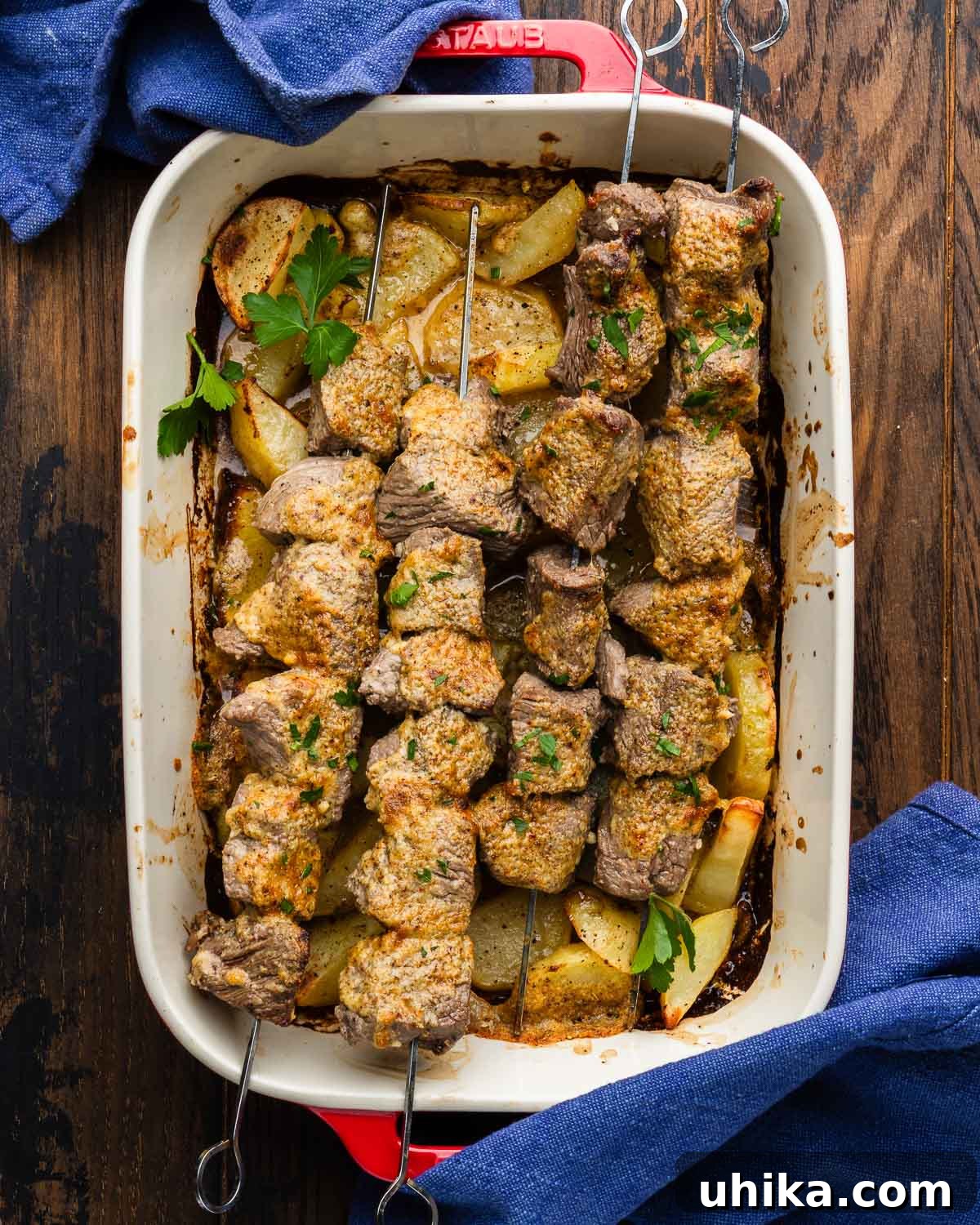 Sheet Pan Parmesan Steak & Crispy Potatoes 2 A large baking dish filled with golden-brown parmesan steak and roasted potatoes, garnished with fresh parsley.