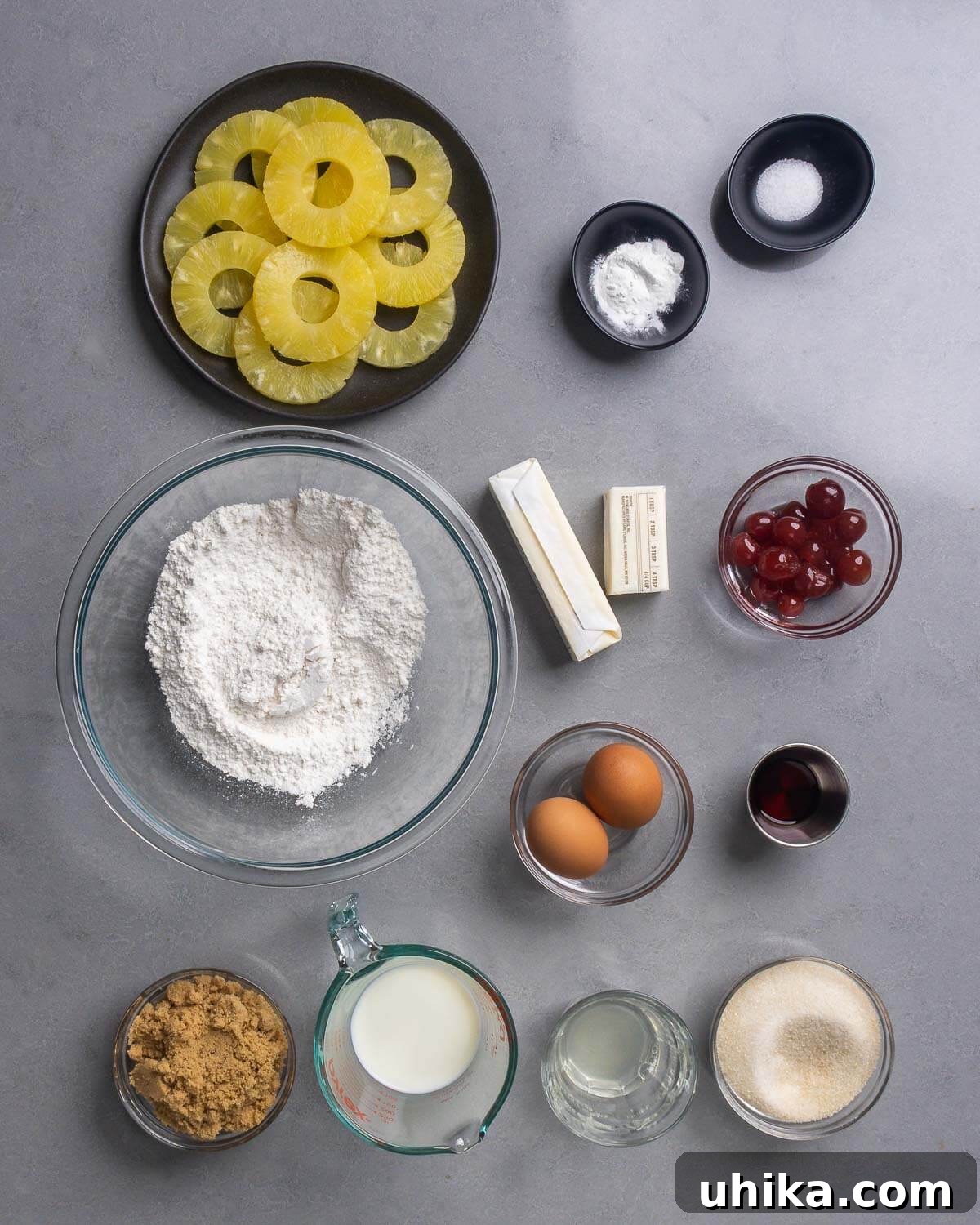 Golden Pineapple Delight 4 Ingredients for Pineapple Upside Down Cake including pineapple rings, baking powder, salt, flour, butter, cherries, eggs, vanilla extract, brown sugar, milk, pineapple juice, and granulated sugar.