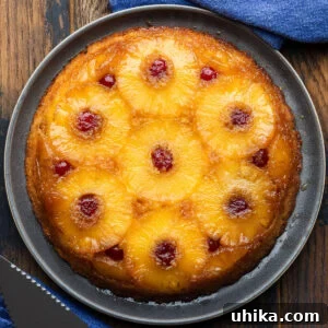 Pineapple upside down cake on grey plate.