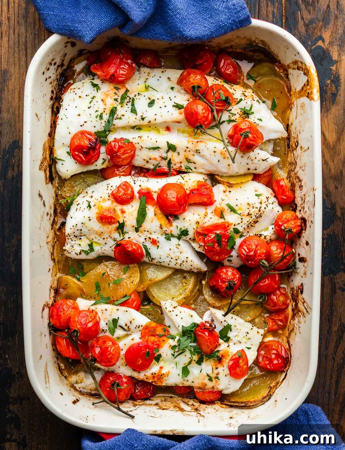 Zesty Lemon Garlic Cod with Golden Potatoes 2 Large baking dish with perfectly baked cod, golden lemon potatoes, and vibrant cherry tomatoes, ready to serve.