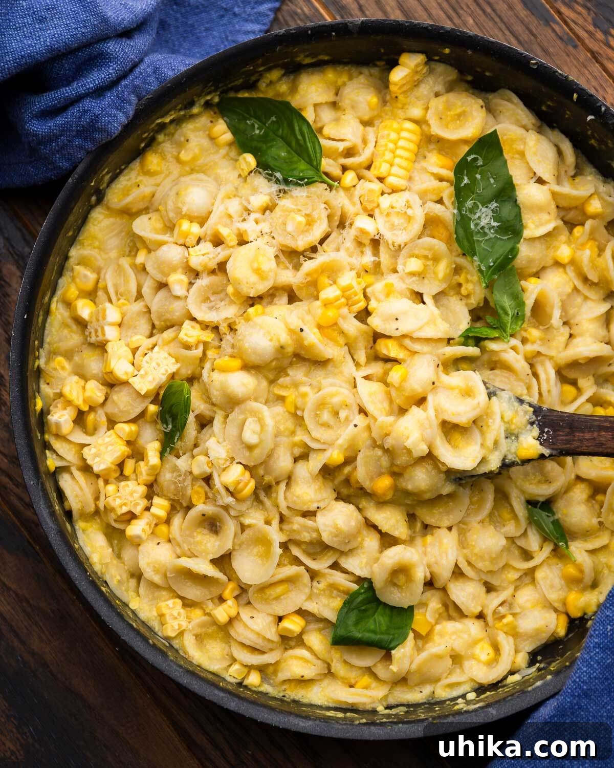 Sunshine in a Bowl: Easy Creamy Corn Pasta 2 Black pan with creamy corn pasta topped with basil leaves.