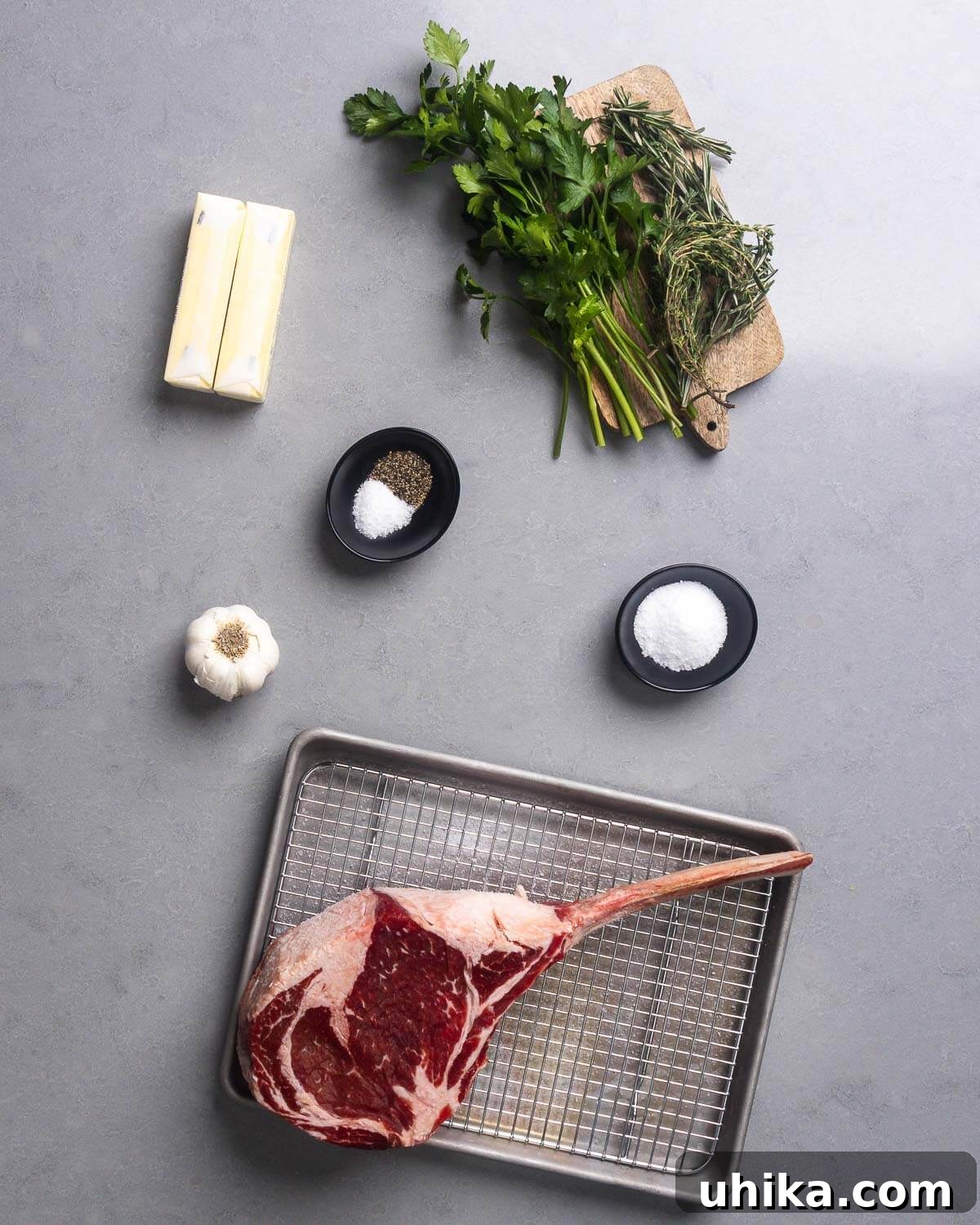 Tomahawk Steak: Grill It Like a Pro 4 Ingredients for grilled tomahawk steak, including butter, parsley, thyme, rosemary, salt, pepper, garlic, and a large tomahawk steak.