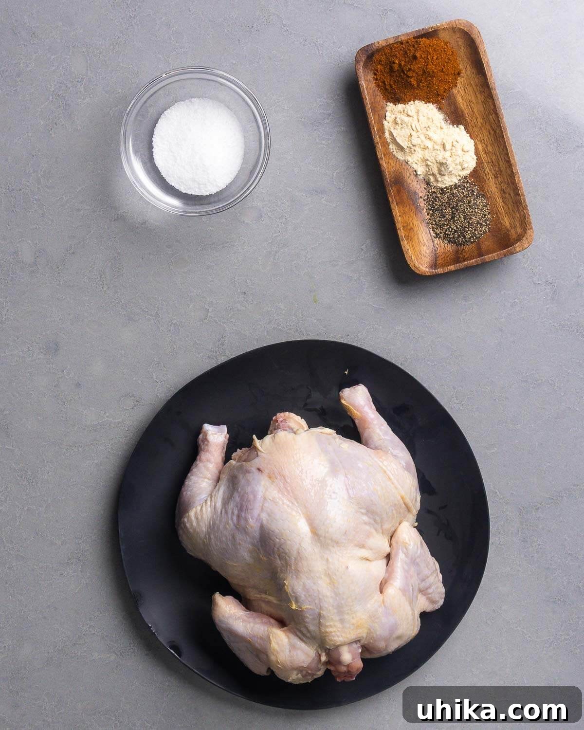How to Make Authentic Rotisserie-Style Chicken at Home 4 Ingredients shown: salt, paprika, garlic powder, onion powder, black pepper, and a whole chicken.