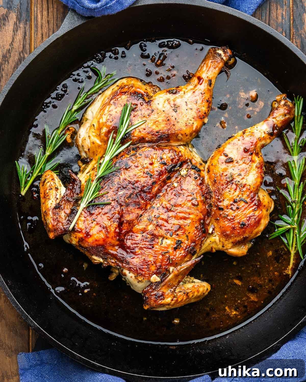 Tuscan Brick-Roasted Chicken with Garlic and Herbs 2 Fully cooked Tuscan chicken under a brick in cast iron pan.