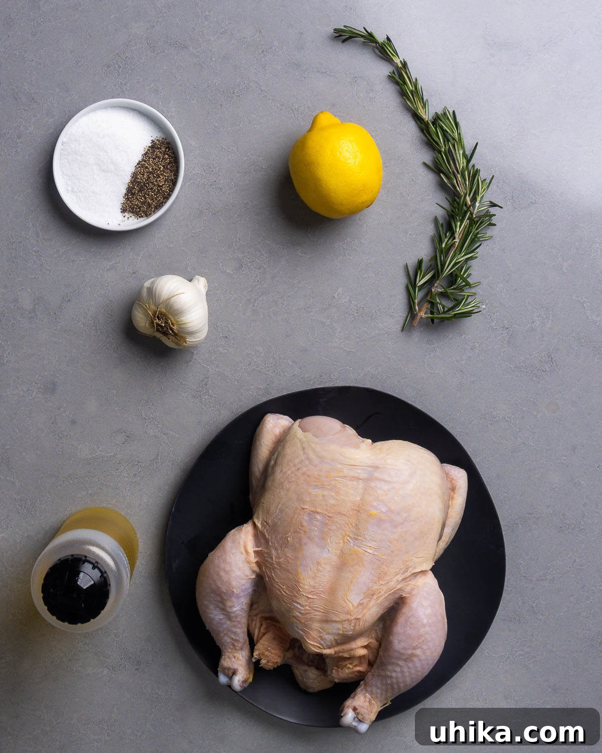 Tuscan Brick-Roasted Chicken with Garlic and Herbs 4 Ingredients shown: salt, pepper, lemon, rosemary, garlic, olive oil, and whole chicken.