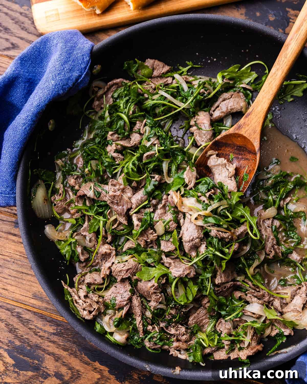 Roman-Style Beef with Peppery Arugula 2 Beef with arugula (little rags) in large black pan.