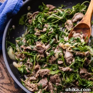 Roman-Style Beef with Peppery Arugula 7 Sauteed beef with arugula in large black pan.