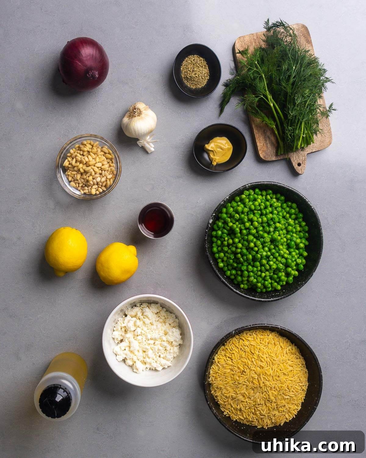 Lemon Herb Orzo Salad — Fresh Summer Side Dish 4 Ingredients shown: small onion, garlic, oregano, dill, Dijon mustard, pine nuts, red wine vinegar, lemons, peas, olive oil, feta cheese, and orzo pasta.
