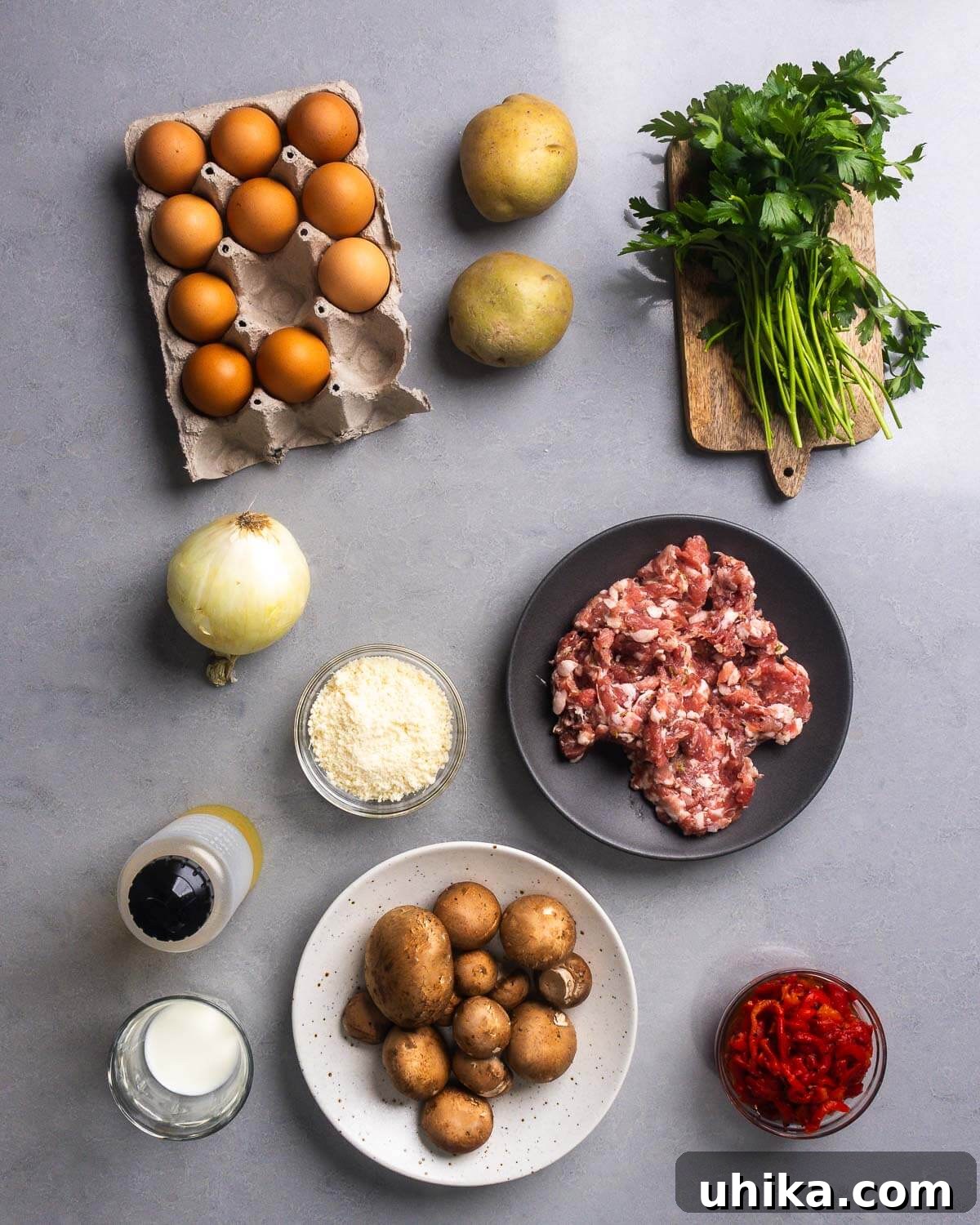Sausage and Mushroom Frittata Recipe for Busy Weeknights 4 Ingredients shown: eggs, potatoes, parsley, onion, parmesan, bulk Italian sausage, olive oil, milk, mushrooms, and roasted red peppers.