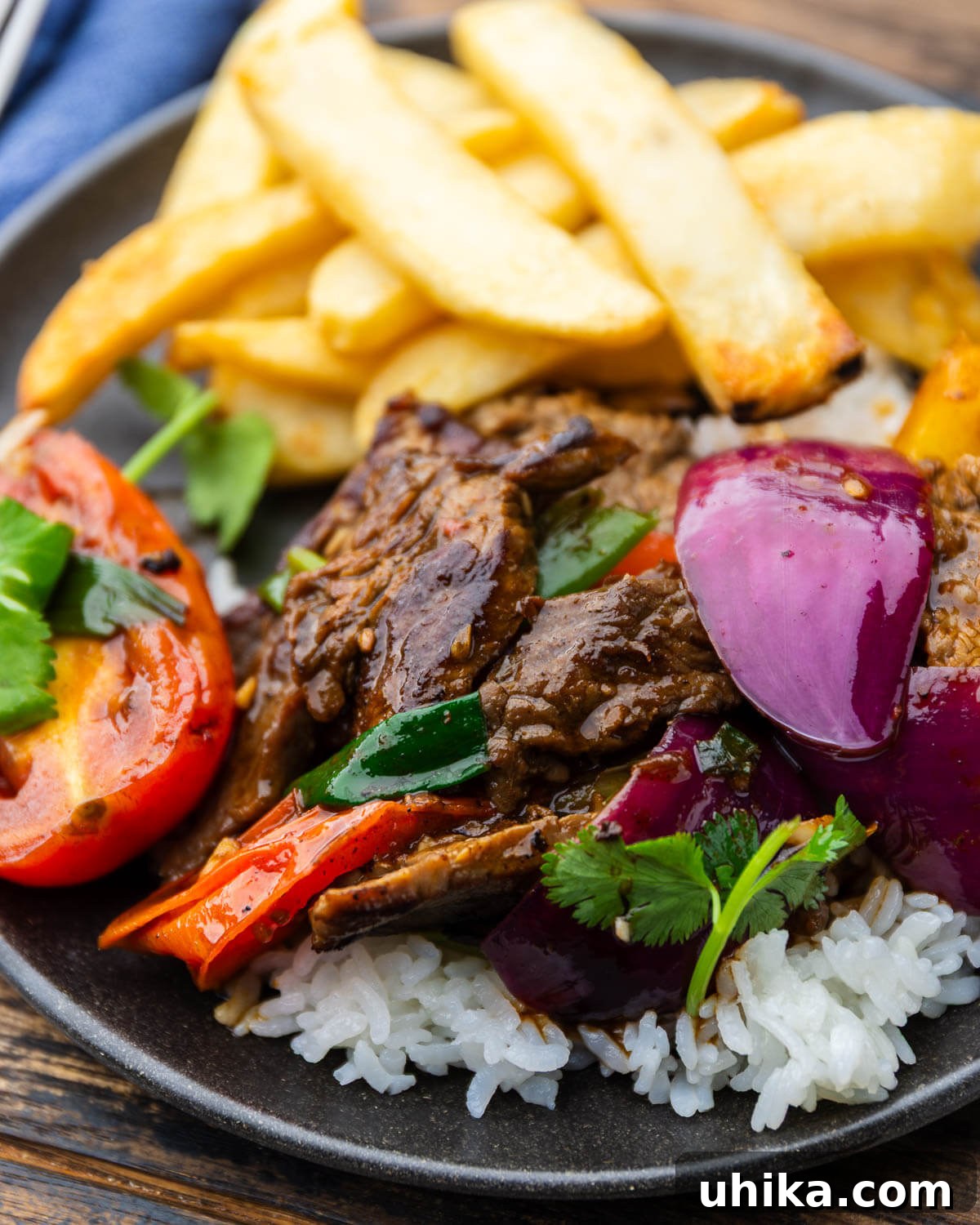 Lomo Saltado: Classic Peruvian Beef Stir-Fry Recipe 2 Lomo saltado over white rice with french fries.