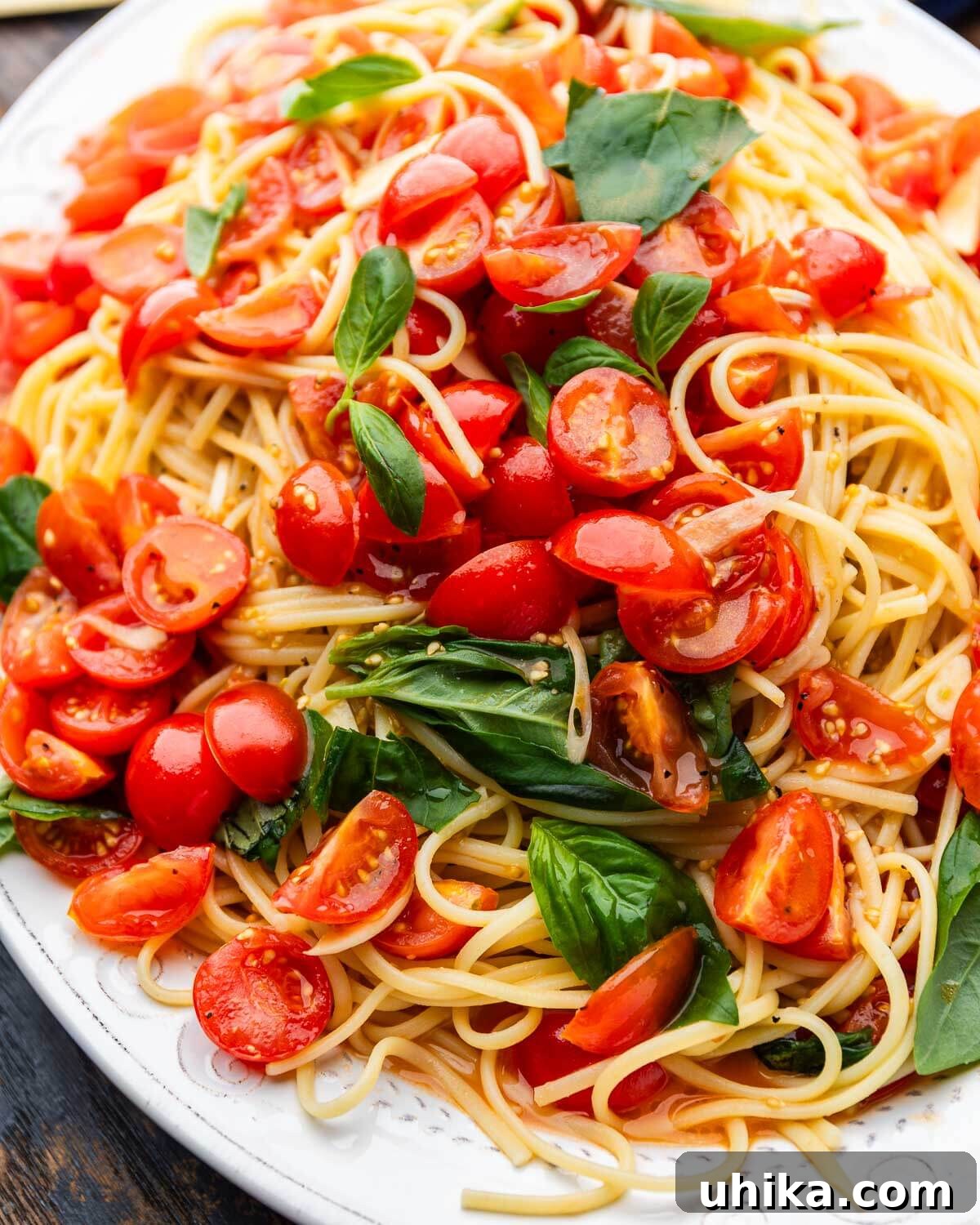 Fresh No-Cook Tomato Sauce Recipe — Perfect Summer Pasta Topping 2 Large platter with linguine topped with an uncooked tomato sauce.